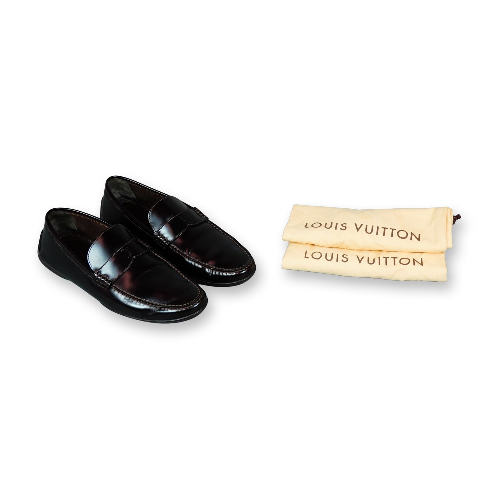 Louis Vuitton Majoe Mahogany Leather Loafers: Louis Vuitton Majoe driving loafers in deep mahogany polished leather, featuring a classic penny strap across the vamp with moc-toe stitching and segmented rubber outsoles. The interiors are lined in 