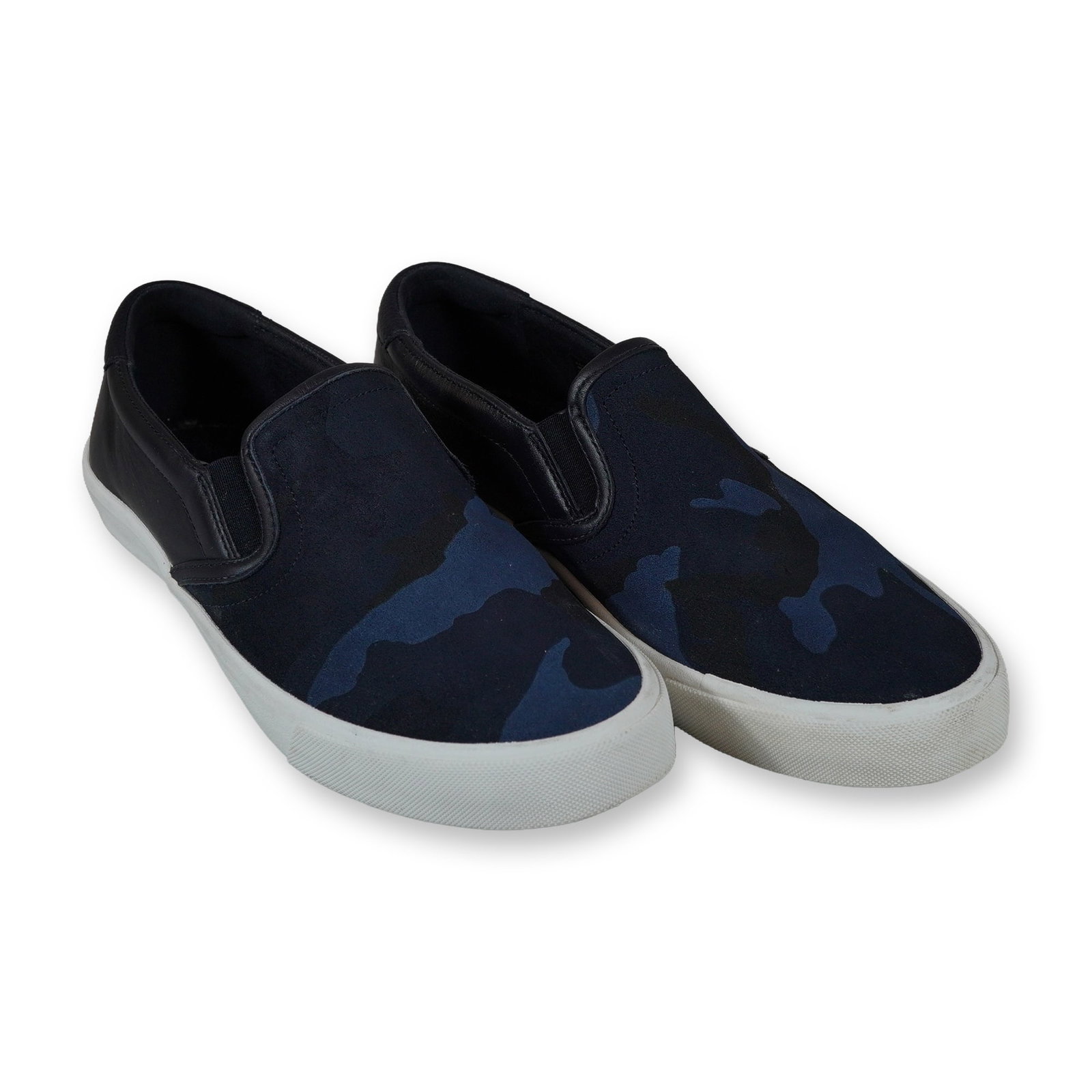 A Pair of Coach Parker Camo Slip On Sneakers: Coach Parker camo slip-on skate sneakers, model FG1664, featuring a navy blue and black camouflage pattern suede upper with black leather trim. Designed with elasticated side gores, textile lining, an