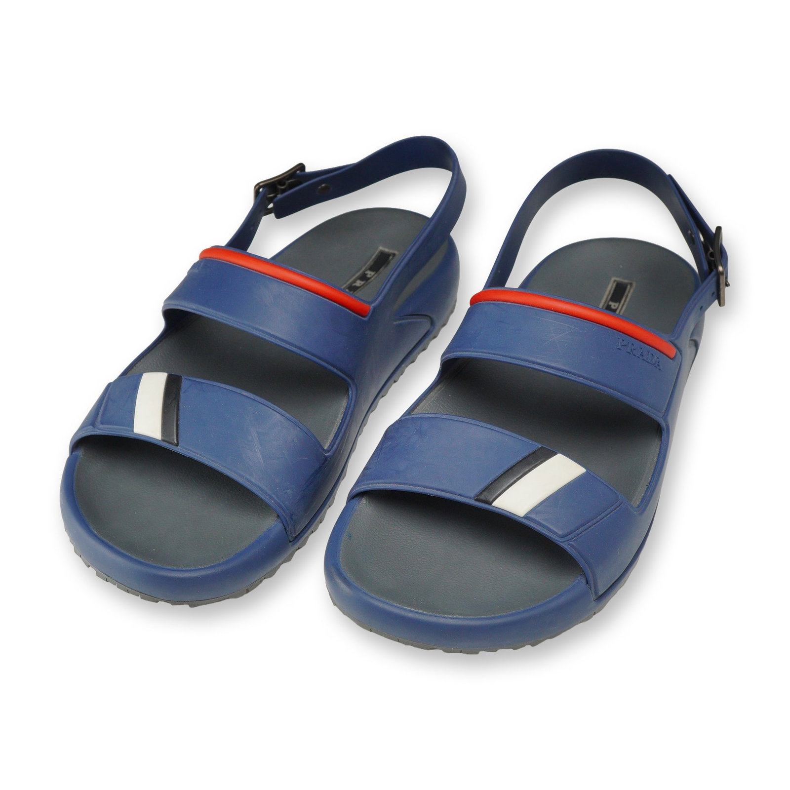 Pair of Prada Linea Rossa Rubber Sandals: Prada Linea Rossa sport double-strap slingback sandals in blue rubber, model 4X3206. Design features dual front straps with red stripe accents, diagonal black and white block details, and adjustable s