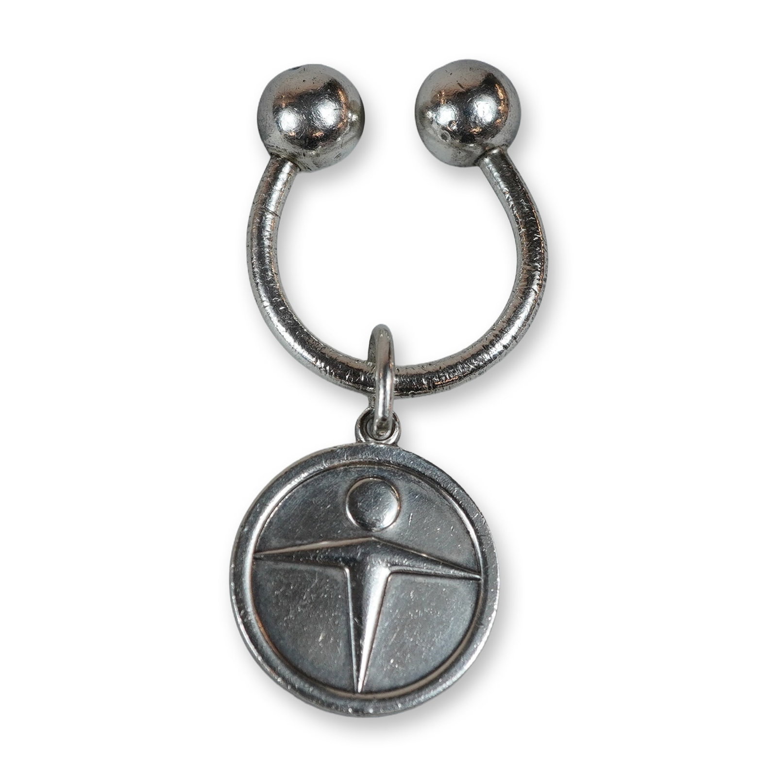 Tiffany & Co. Sterling Silver Man Power Keychain: Tiffany & Co. Horseshoe-style keychain in sterling silver, featuring a circular pendant with a stylized human figure in relief. Includes a signature blue fabric drawstring dust cover. Charm reverse ma