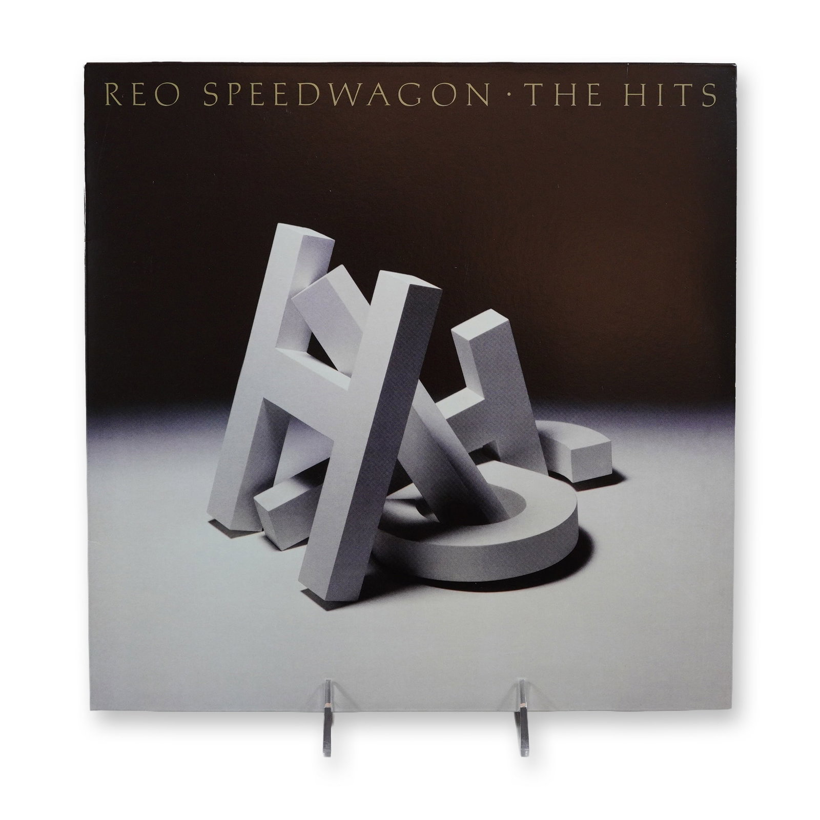 REO Speedwagon The Hits Vinyl LP Record: REO Speedwagon, The Hits. Single 12-inch vinyl LP, 2020 reissue of the 1988 compilation. Epic Records, catalog number 19439764001 (barcode 194397640014). The jacket features original 1988 artwork desi