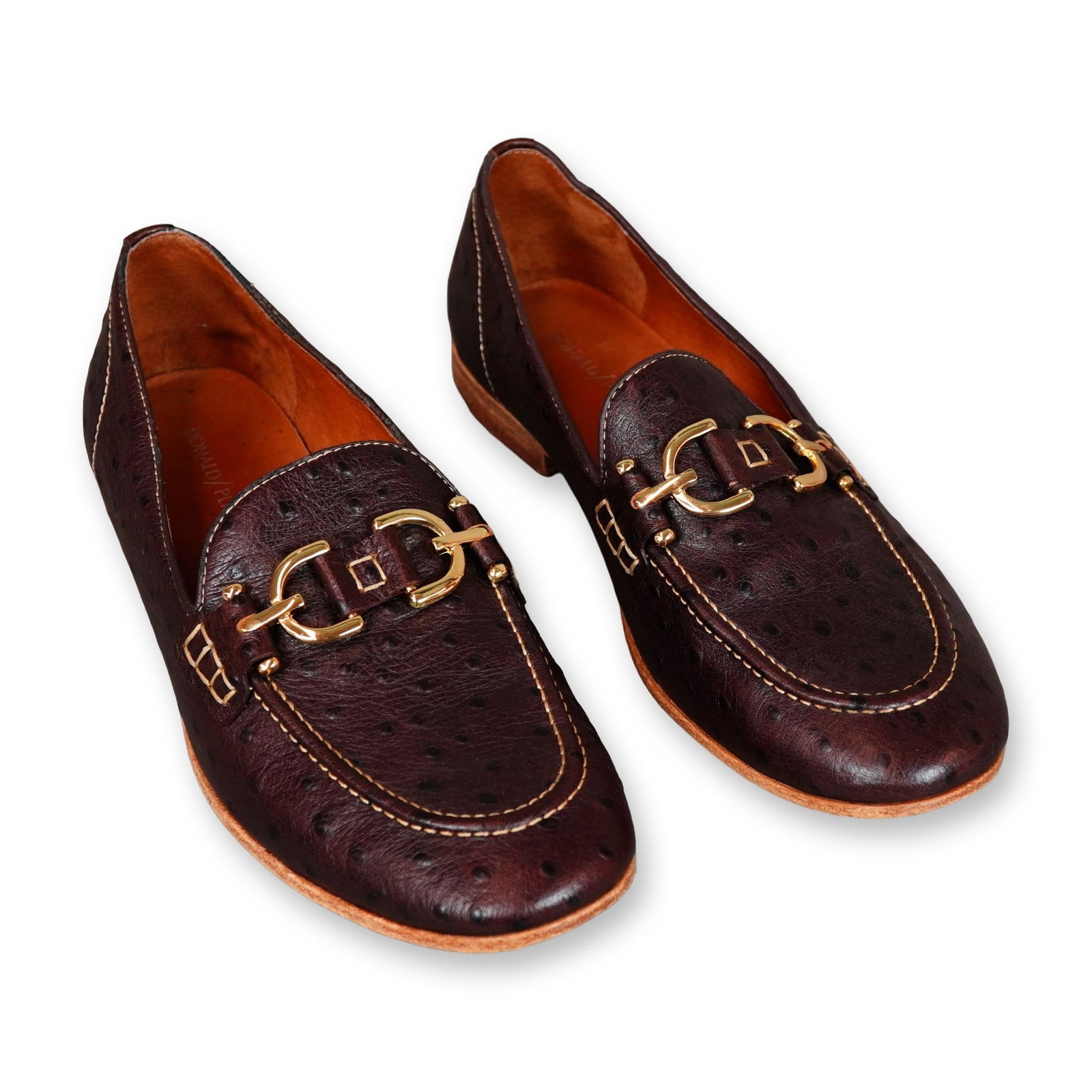 Pair of Donald Pliner Moritz Ostrich Embossed Leather Loafers: A pair of Donald Pliner Moritz slip-on bit loafers, crafted in dark espresso brown ostrich-embossed leather. The design features a classic moc-toe silhouette, stitched detailing, and gold-tone metal h