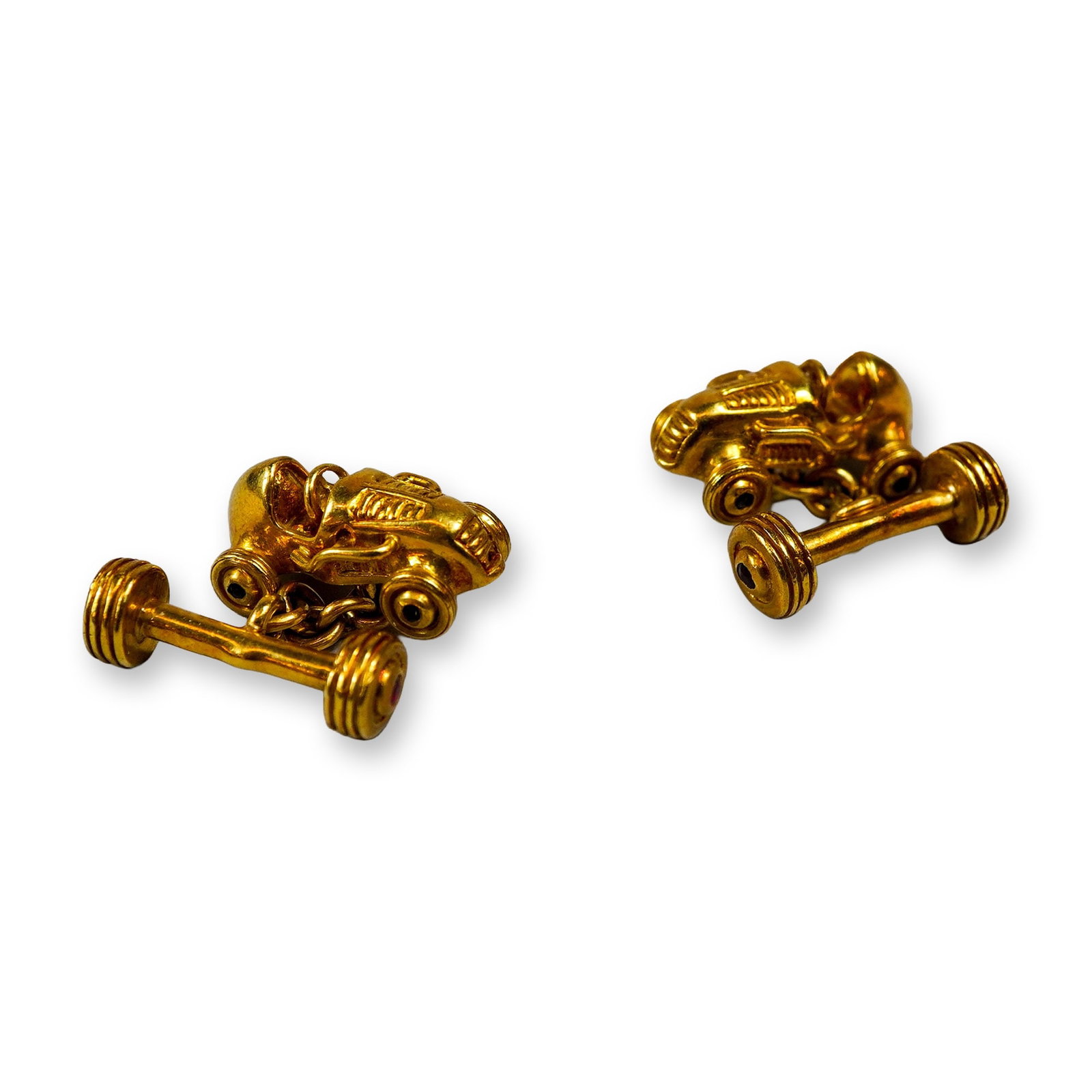 Mish 18K Yellow Gold Roadster Cufflinks: Pair of cufflinks in 18k yellow gold, designed in the form of vintage open-cockpit roadsters. The roadster forms feature round-cut sapphires set into the wheel hubs and round-cut rubies set into the s