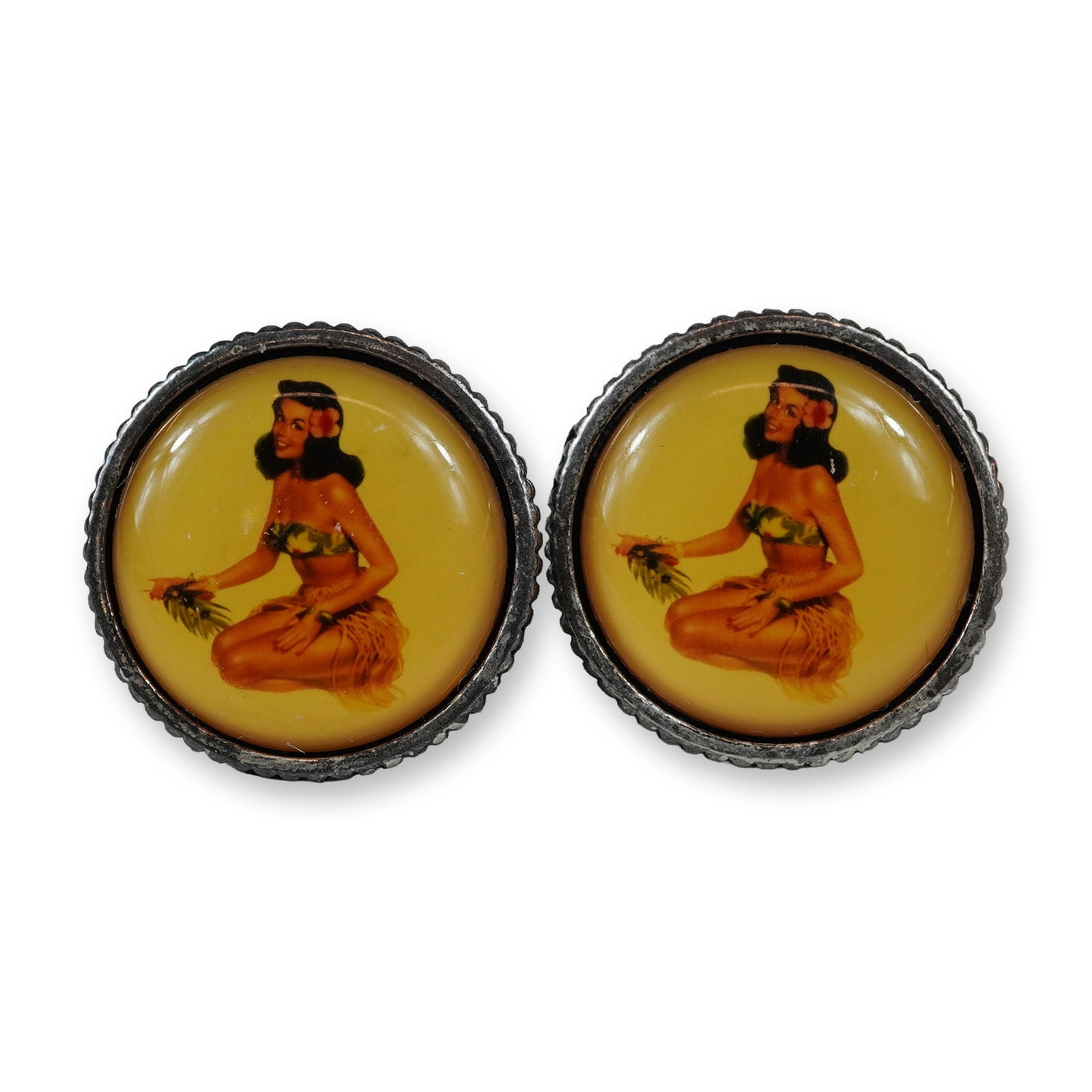 2pc Avon Hula Girl Pin-Up Cufflinks: This mid-century modern-style pair of novelty cufflinks is crafted in silver-tone base metal with a heavily patinated finish. Each circular face features a vintage-style pin-up illustration of a kneel