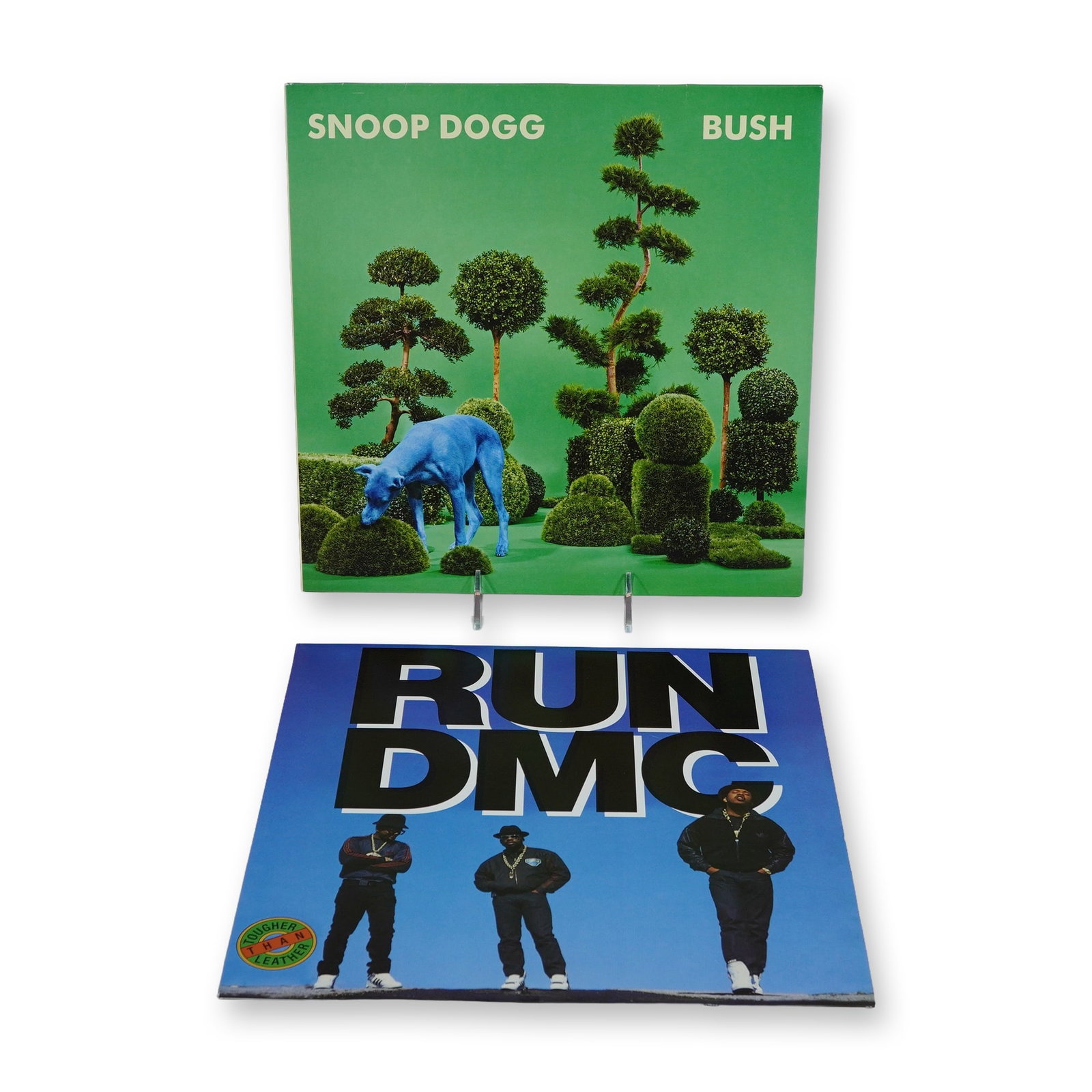 Two Snoop Dogg and Run-D.M.C. Hip-Hop Vinyl LP Records: Two hip-hop vinyl LP records featuring Snoop Dogg and Run-D.M.C. The first is Snoop Dogg, Bush, released in 2015 by Columbia and Sony Music Entertainment, pressed on translucent blue vinyl. It is hous