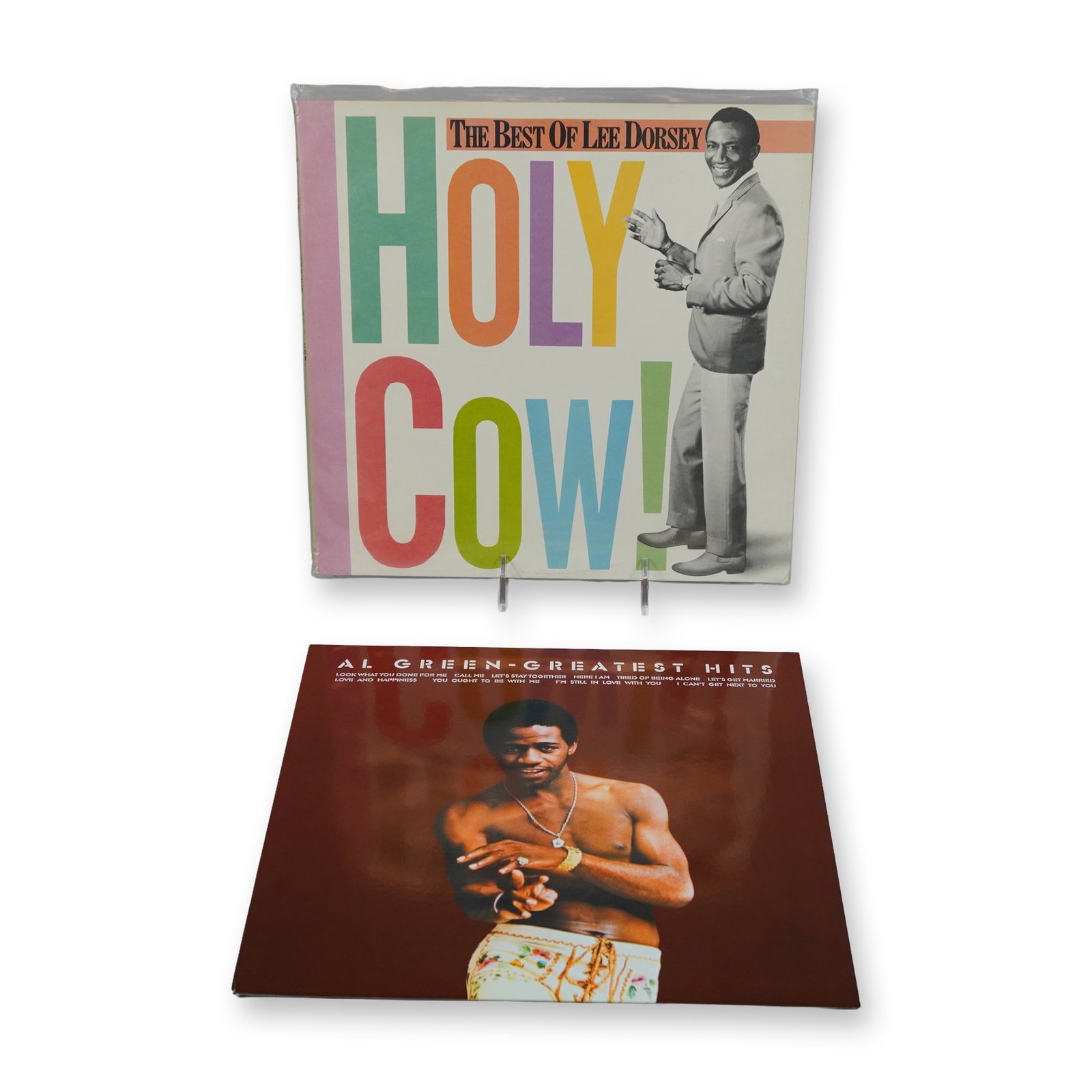 Two The Best of Lee Dorsey and Al Green Greatest Hits Vinyl LP Records: Two vinyl LP records featuring classic R&B and soul artists. The collection includes The Best of Lee Dorsey - Holy Cow!, a compilation released by Arista Records in 1985 (AL8-8387), featuring tracks w