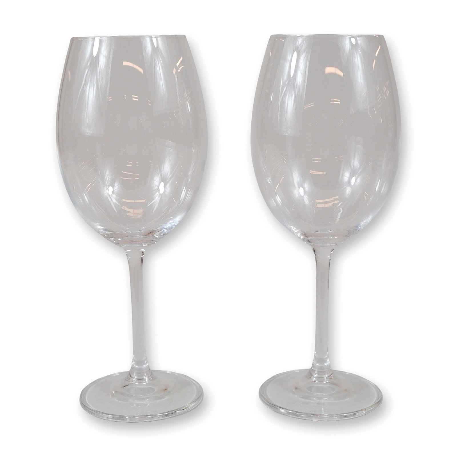 A Pair of Mikasa Crystal Large Wine Glasses: A pair of Mikasa clear crystal wine glasses. Each glass features a large, rounded bowl that tapers slightly toward the rim, supported by a long, slender stem and a flat, circular foot. The design is