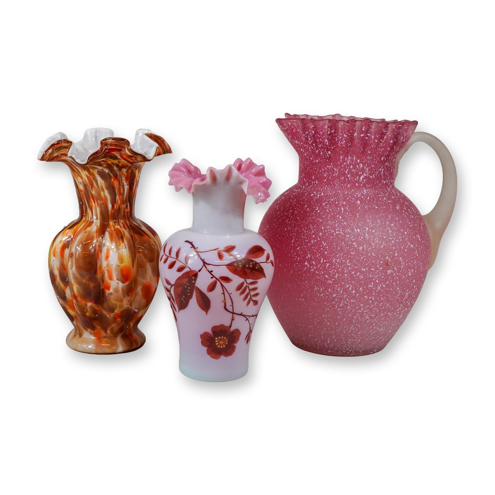 3pc Victorian Style Art Glass Vessels: Trio of Victorian style art glass pieces including a pitcher and two unique colorful art glass vases. The largest item is a pink cased glass pitcher featuring white spangle or snowflake inclusions, a 