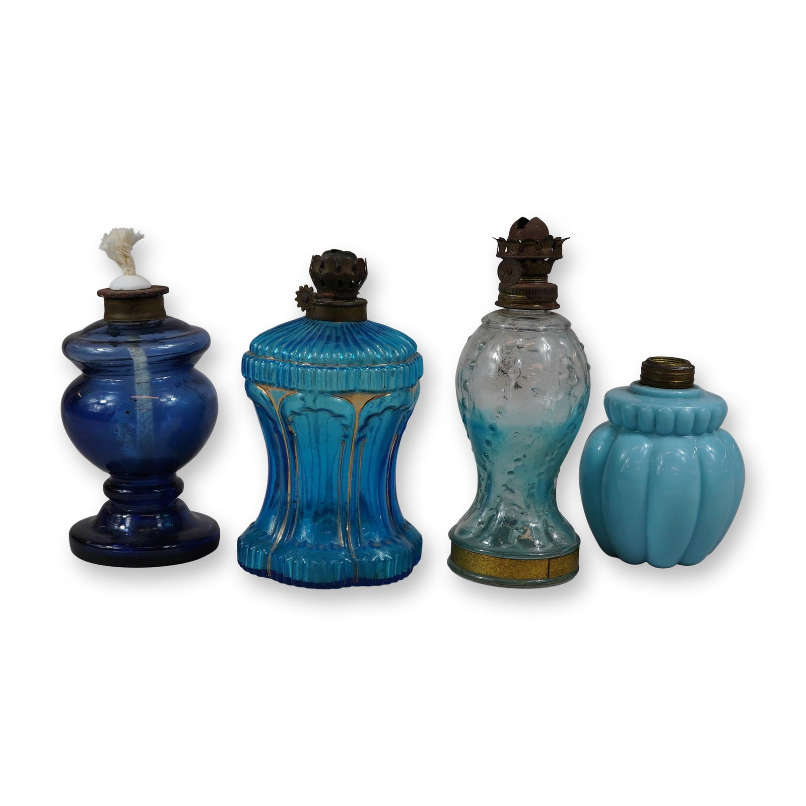 4pc Vintage Blue Miniature Glass Oil Lamps: This is a 4pc collection of vintage miniature glass oil lamps, commonly known as night or nursery lamps, featuring a blue theme. The set includes a transparent cobalt blue blown glass lamp in a pedest