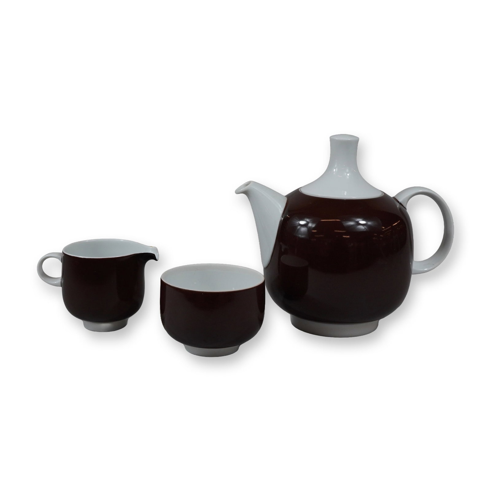 3pc Rosenthal Studio-linie Germany Teapot with Creamer and Sugar Bowl in Plus Pattern: This three-piece porcelain tea service is from the Rosenthal Studio-linie Plus range, designed by Wolf Karnagel. The set is constructed of porcelain with a two-tone glazed finish. The exterior of each