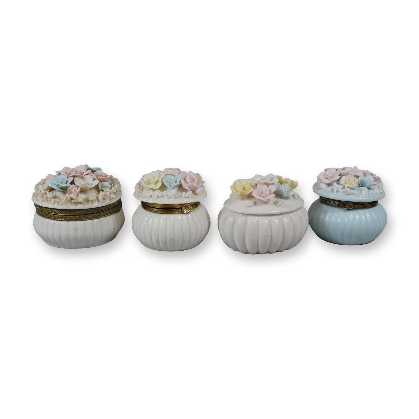 A Lot of Four Japanese Porcelain Floral Trinket Boxes: A lot of four porcelain floral trinket dishes of Japanese origin. The collection includes four circular boxes characterized by gadrooned or ribbed sides. Three boxes are finished in a white glaze, whi