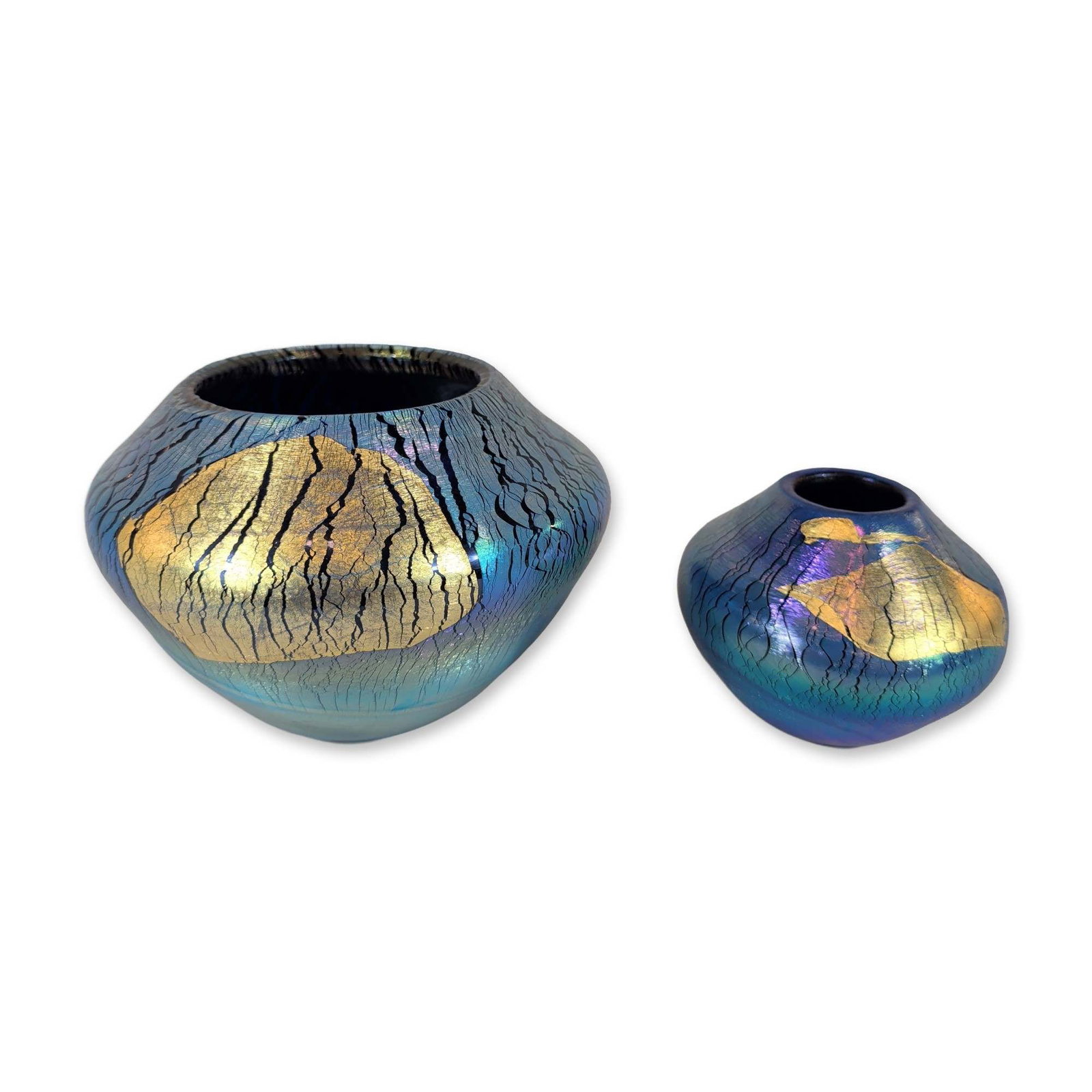 2pc Robert Eickholt Iridescent Gold Leaf Glass Vases: Pair of Robert Eickholt studio blown glass vases in a compressed globular form, featuring iridescent surfaces in shades of cobalt blue and violet with dark crackle veining. Each vessel is decorated wi