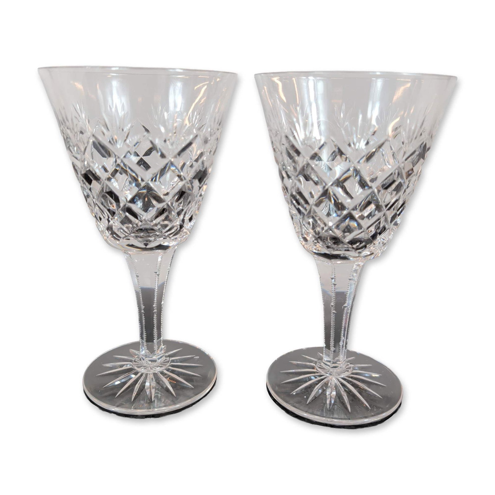 Pair of Cut Crystal Wine Glasses: Pair of lead crystal wine glasses. The bowls feature deep diamond cross-hatch cutting below a border of vertical wedge cuts. Each glass is supported by a faceted hexagonal stem with notched edges,