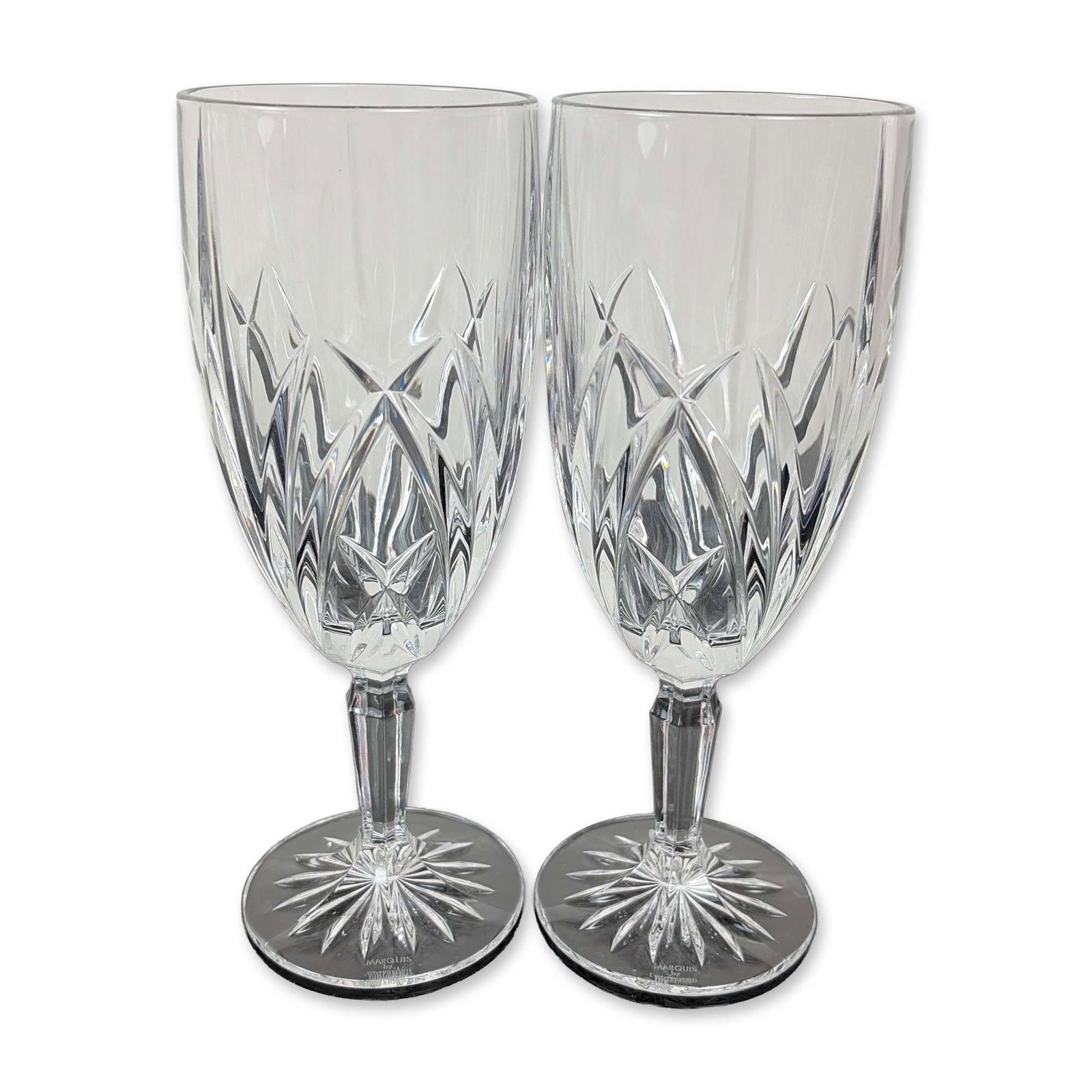 Pair of Marquis by Waterford Crystal Brookside Iced Tea Glasses: Each bowl features a lower register of deep-cut crisscross diamond motifs beneath upright wedge cuts. The design includes a multi-faceted stem and a circular foot with an underside starburst cut.