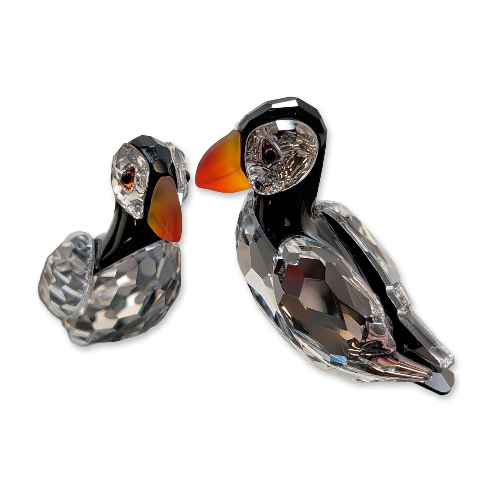 Swarovski Crystal Figurine, Puffins by Martin Zendron: Swarovski crystal figurine, Atlantic Puffins rendered in faceted clear and black lead crystal with orange gradient beaks, perched upon a textured frosted crystal base representing an ice floe. Designe