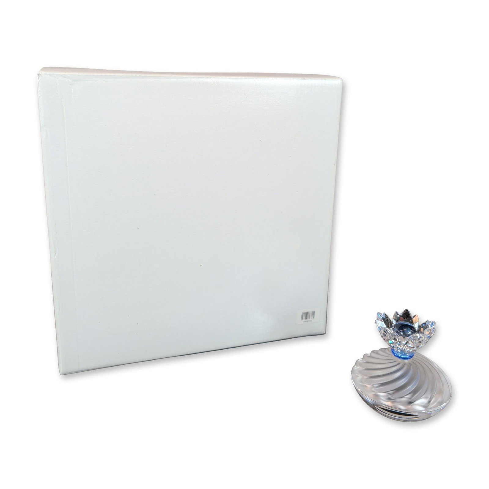 Swarovski Crystal SCS Blue Flower Jewel Lidded Box: Swarovski crystal jewel box piece consists of a clear glass bowl base and a corresponding lid with a swirled, fluted design. The lid is surmounted by a multifaceted crystal floral finial, featuring a 