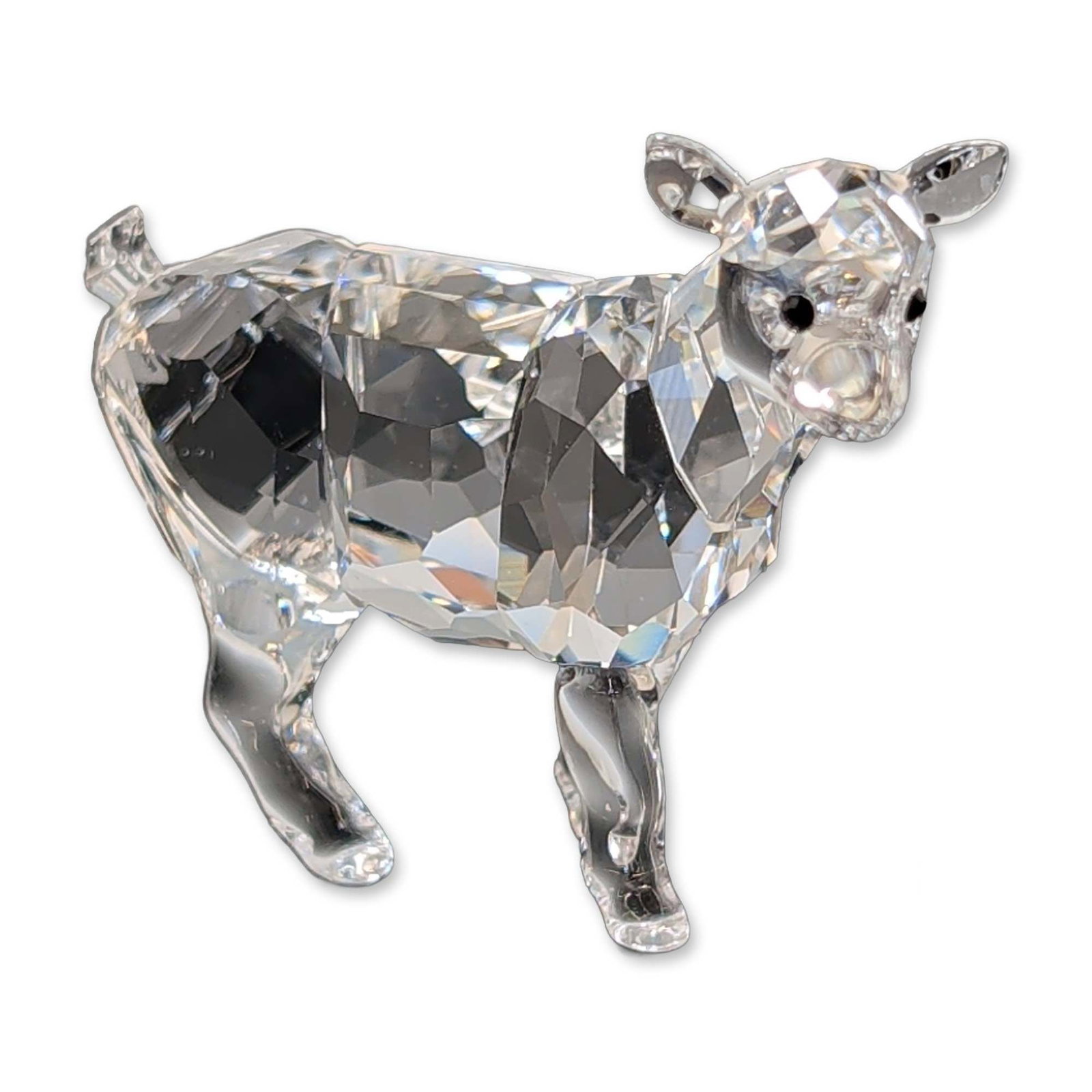 Swarovski Faceted Crystal Figurine, Goat Kid: Swarovski goat kid figurine in faceted clear crystal, featuring a stylized body with black crystal eyes and textured detailing on the body. Laser-etched Swarovski swan mark to the underside of one leg