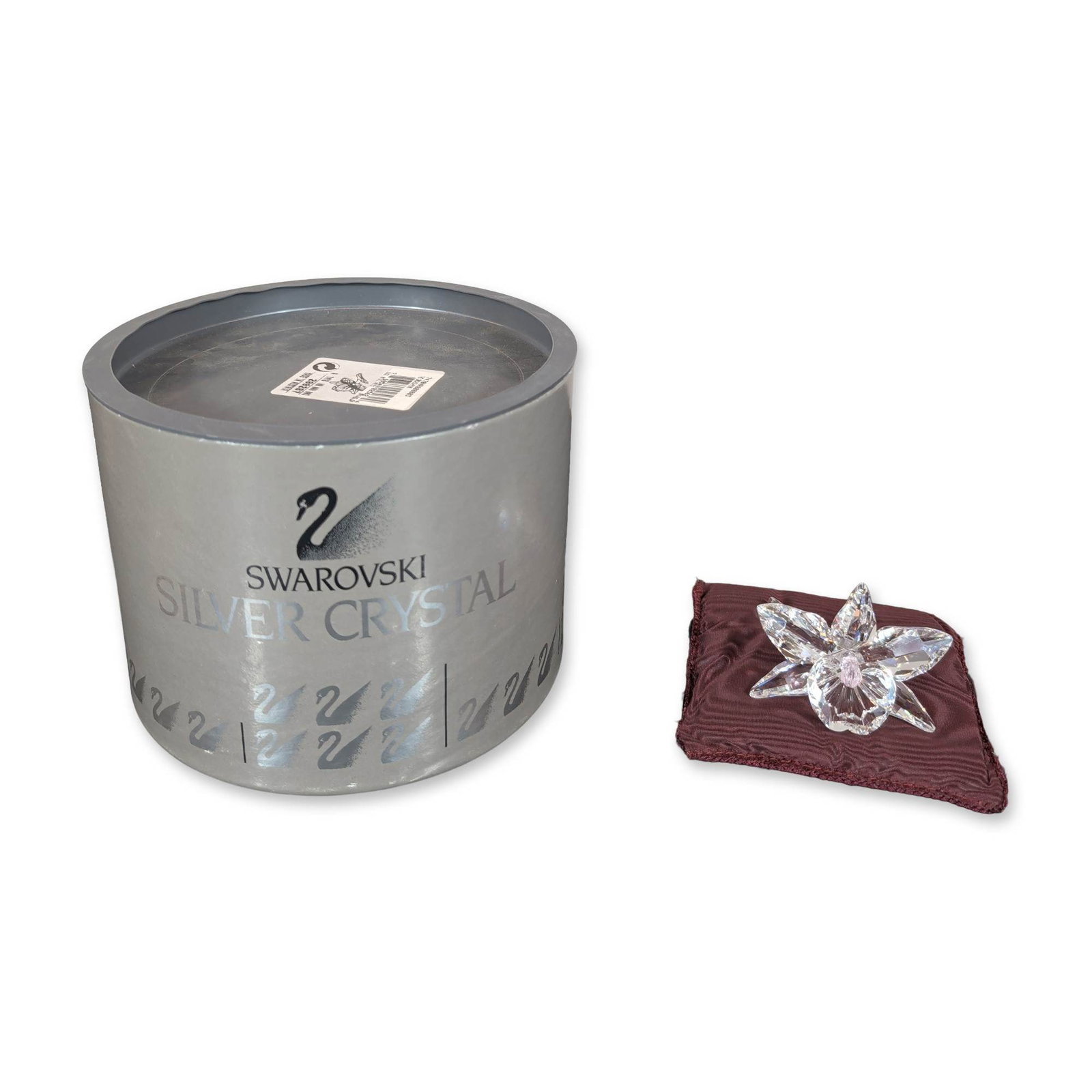 Swarovski Silver Crystal Orchid Flower Figurine: The piece features five pointed petals surrounding a multi-faceted center accented with a pale pink crystal bead, mounted on a curved integral stem with a flared circular base. Includes a small maroon
