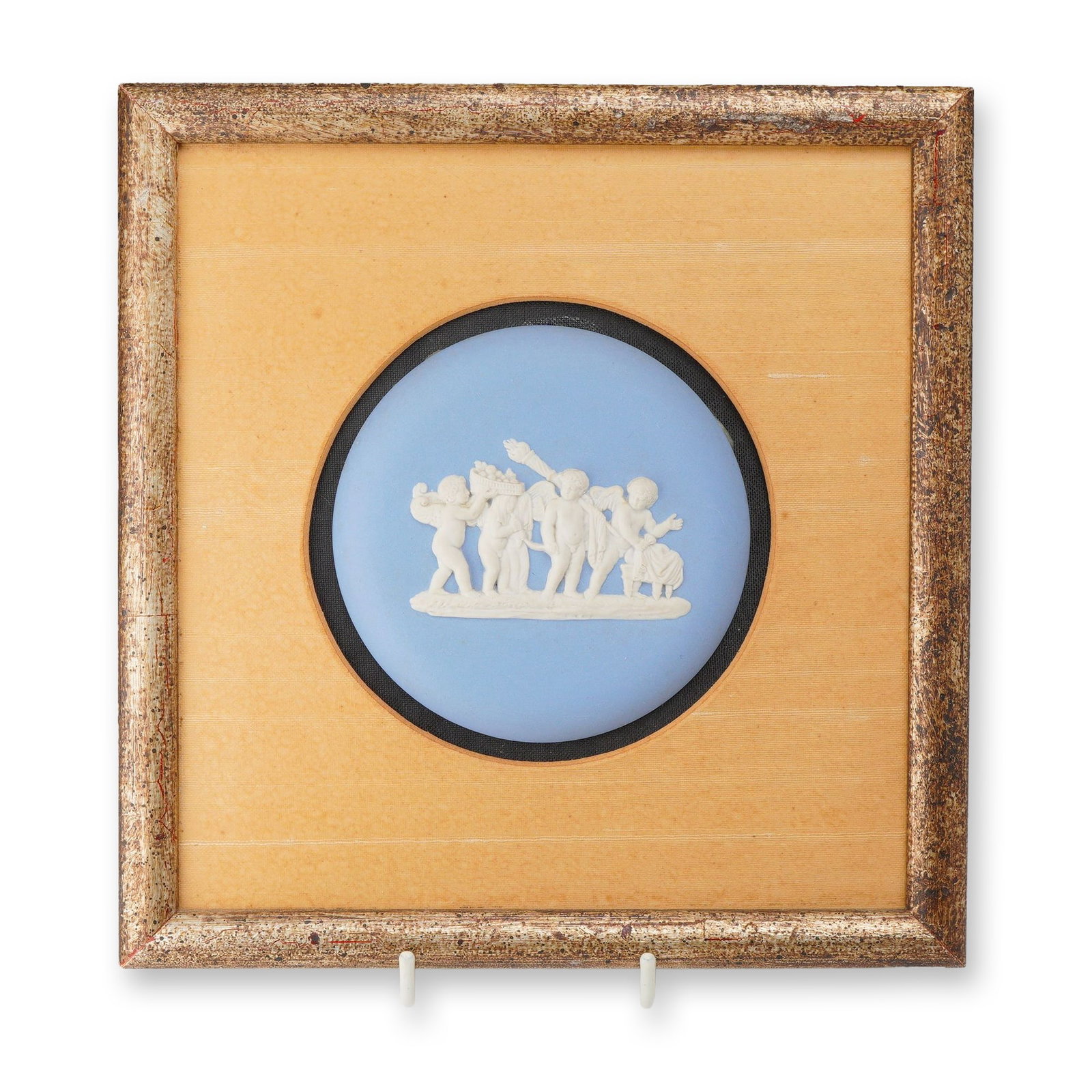 Wedgwood Blue Jasperware Classical Medallion Framed: This circular jasperware medallion features a Neoclassical bas-relief in white clay sprigged onto a matte light-blue ground. The central frieze depicts a procession of five putti, with one figure carr
