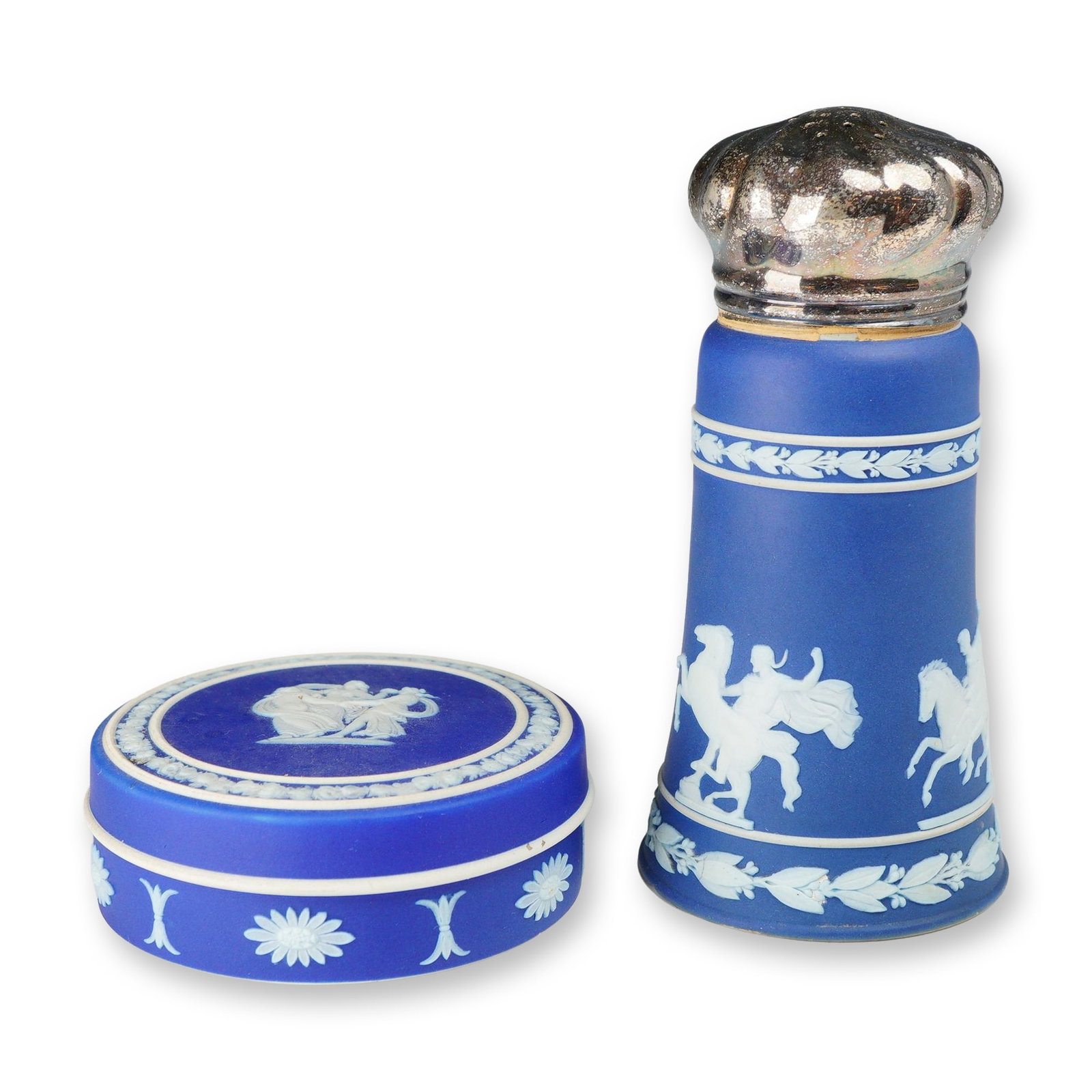 Lot of 2 Wedgwood Dark Blue and White Jasperware Pieces: Pepper Shaker and Lidded Trinket Box: This lot consists of two pieces of cobalt blue jasperware manufactured by Wedgwood in England. The collection includes a circular lidded trinket box and a tapered cylindrical shaker, both featuring th