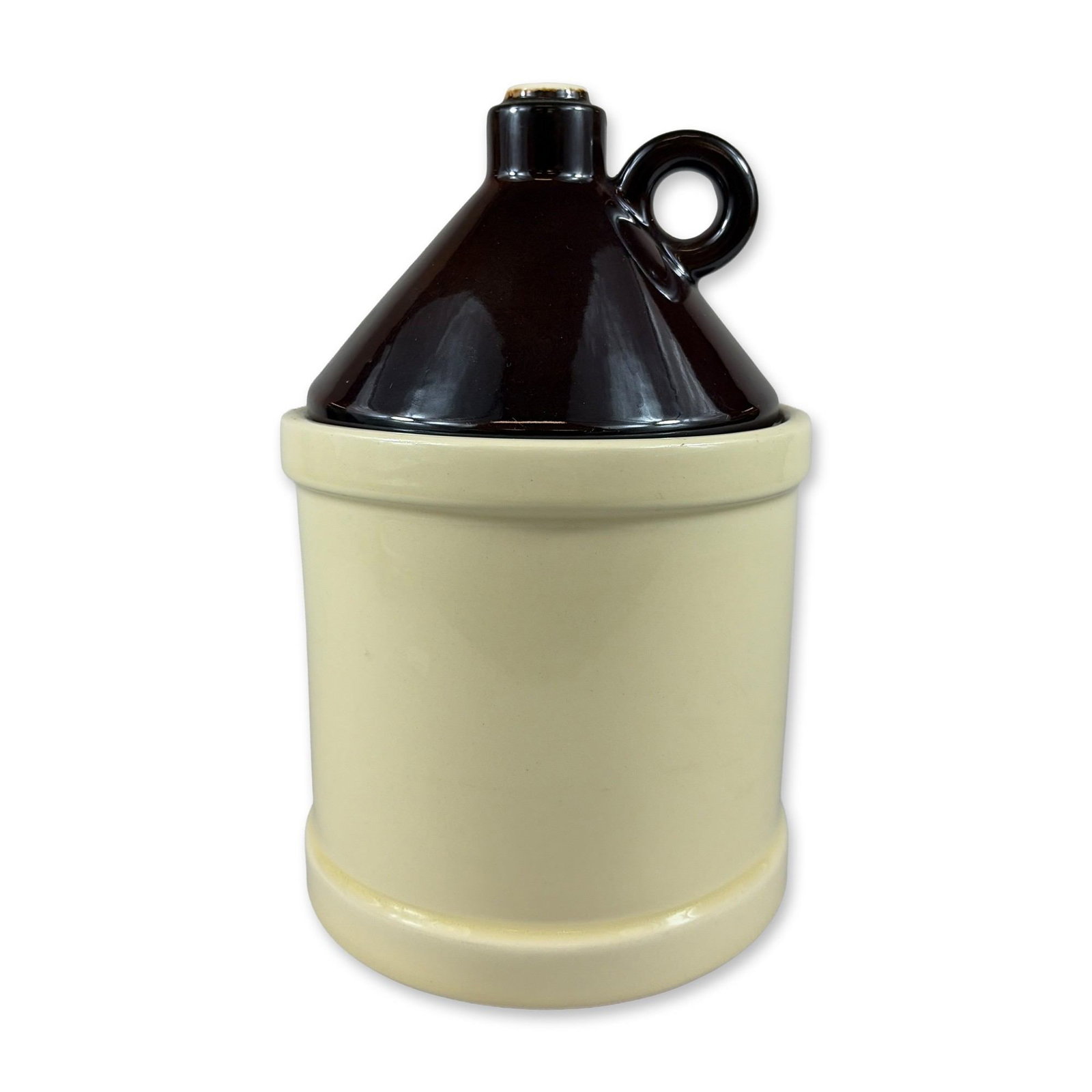 McCoy Ceramic Moonshine Jug Cookie Jar: Featuring a cream-colored cylindrical body and a dark brown glazed conical lid with an integrated finger loop and spout detail. USA and 1004 marked on the underside. Dimensions: 10"H Manufacturer or B