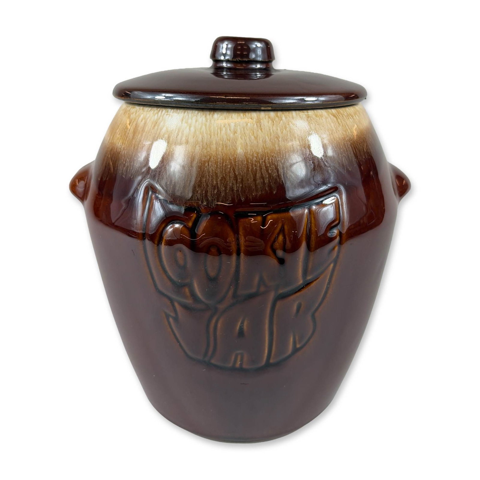 McCoy Ceramic Brown Drip Cookie Jar: Ceramic cookie jar, model 7024, featuring a high-gloss brown drip glaze in chocolate and honey tones. The vessel is of tapered cylindrical form with two integrated lug handles and prominent relief let