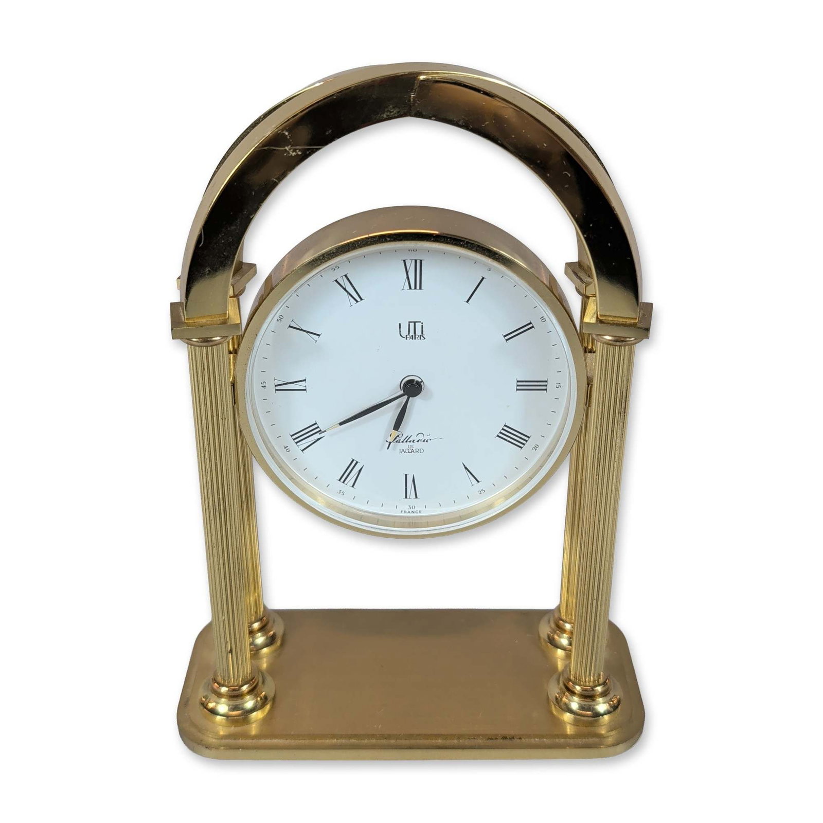 UTI Paris Palladio Gilt Metal Desk Clock: French desk clock in gilt metal by UTI Paris, Palladio de Jaccard model, featuring a circular timepiece suspended between two fluted columns on a rectangular base. The white dial is printed with