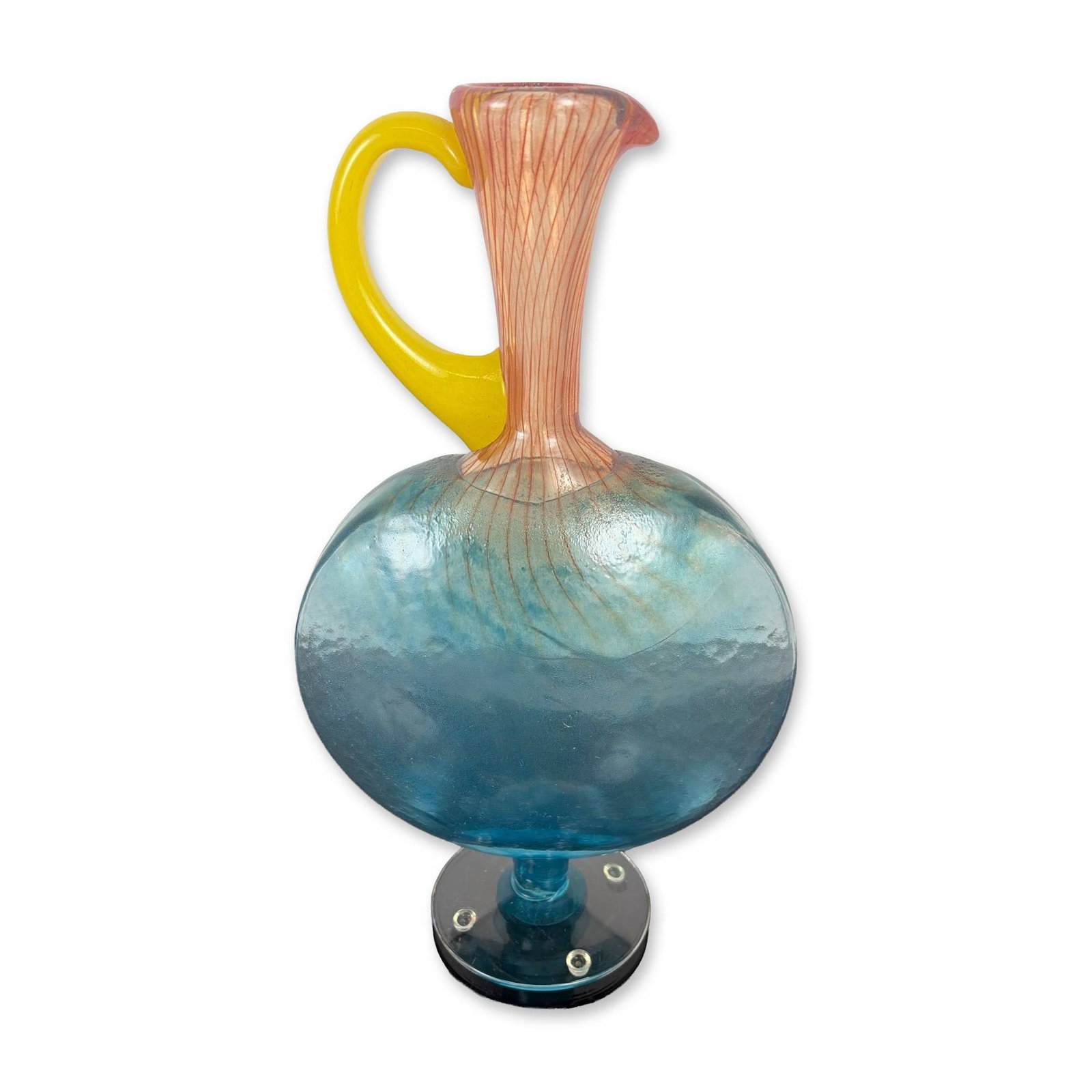 Kjell Engman Kosta Boda Bon Bon Glass Jug: Kjell Engman for Kosta Boda Bon Bon series art glass jug. Hand-blown vessel featuring a flattened globular body of translucent light blue glass with a hammered surface texture. The elongated neck cont