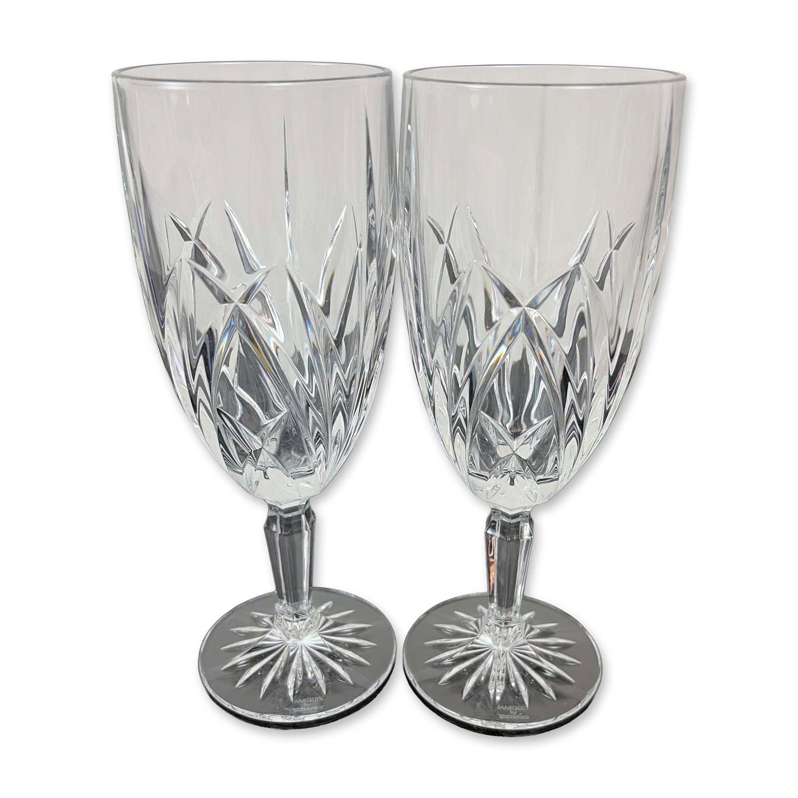 Pair of Marquis by Waterford Crystal Brookside Iced Tea Glasses: Each bowl features a lower register of deep-cut crisscross diamond motifs beneath upright wedge cuts. The design includes a multi-faceted stem and a circular foot with an underside starburst cut. Both