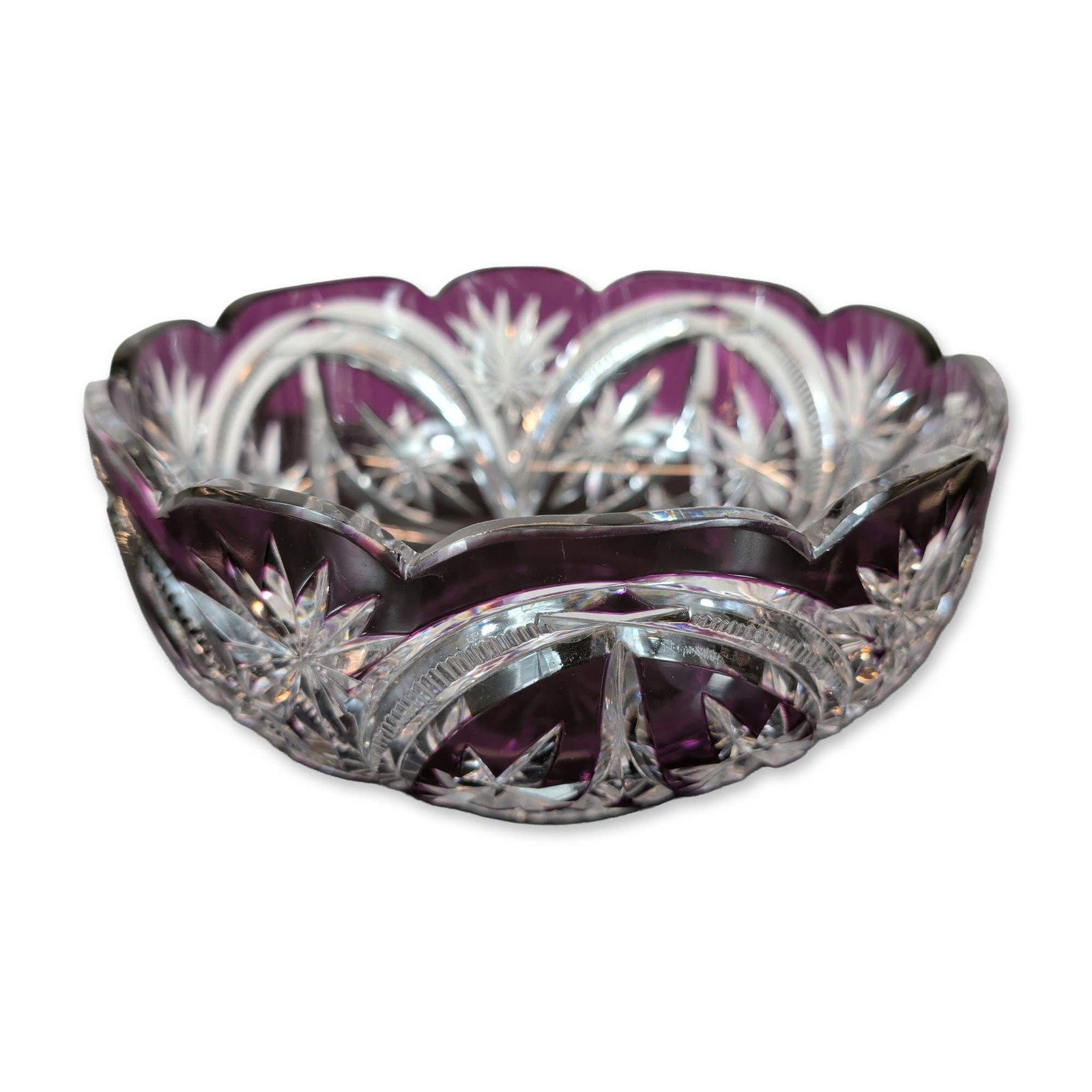 Bohemian Style Amethyst Cased Crystal Bowl: Bohemian style pedestal bowl in amethyst cased to clear lead crystal, featuring hand-cut hobstars, fans, and architectural arch motifs. The piece includes a scalloped rim and a large radiating starbur
