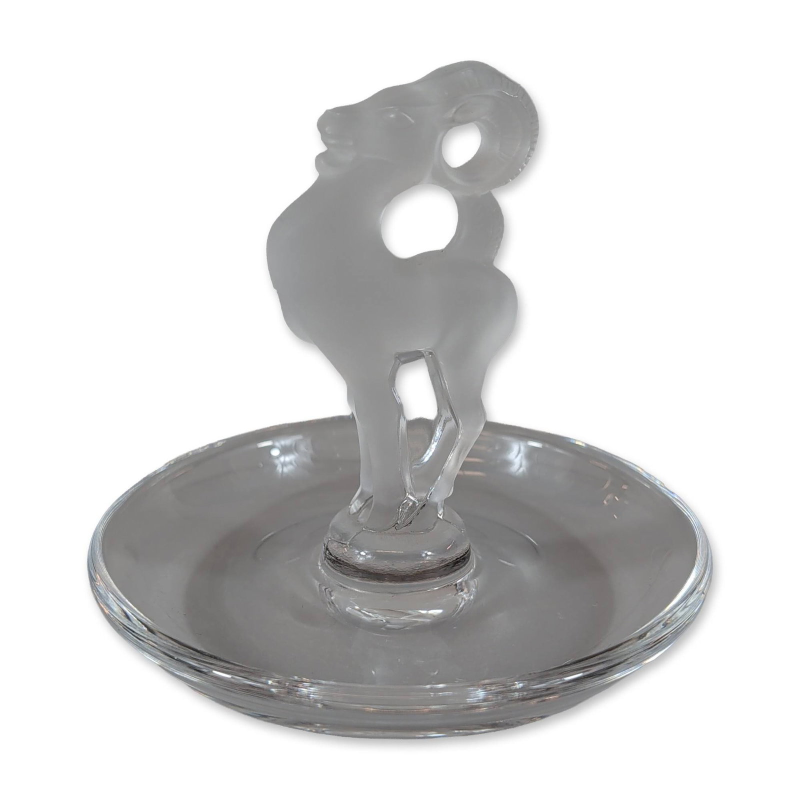 Lalique France Frosted Crystal Ram Ring Dish: Lalique, France. A crystal ring tray or small decorative dish featuring a central frosted glass stem in the form of a crouching ram. The figure is set within a shallow clear glass bowl upon a circular