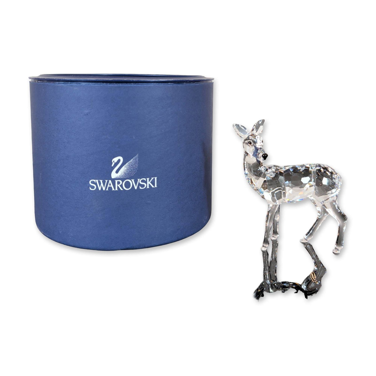 Swarovski Crystal Doe Figurine: Swarovski standing doe figurine in clear faceted lead crystal, featuring small black crystal accents for the eyes and nose. Etched swan maker mark located on the rear haunch. Includes original blue an