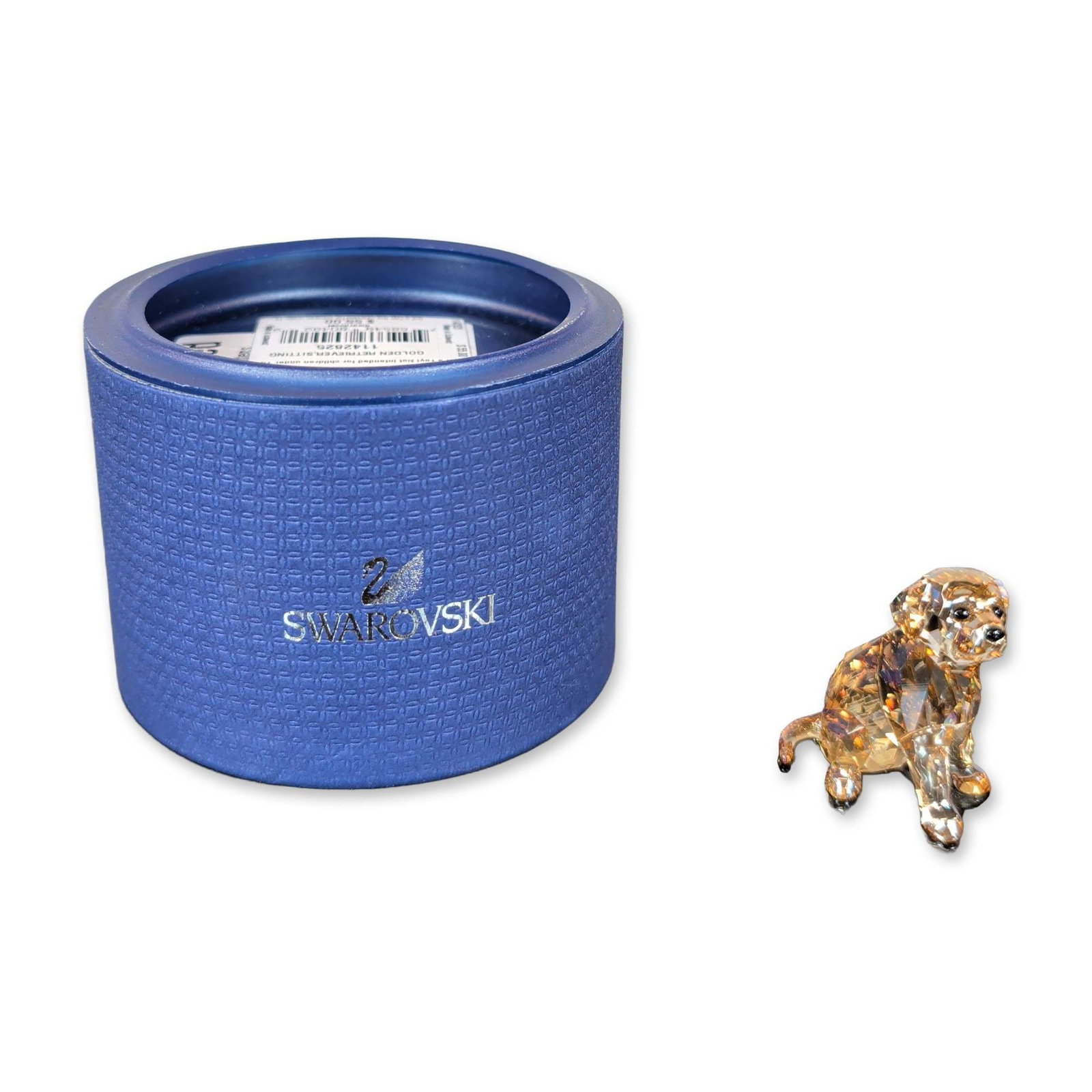 Swarovski Crystal Golden Retriever Puppy Figurine: Swarovski figurine in faceted lead crystal depicting a sitting Golden Retriever puppy. Crafted from honey-gold colored faceted crystal with clear accents, featuring black crystal bead eyes and nose. M