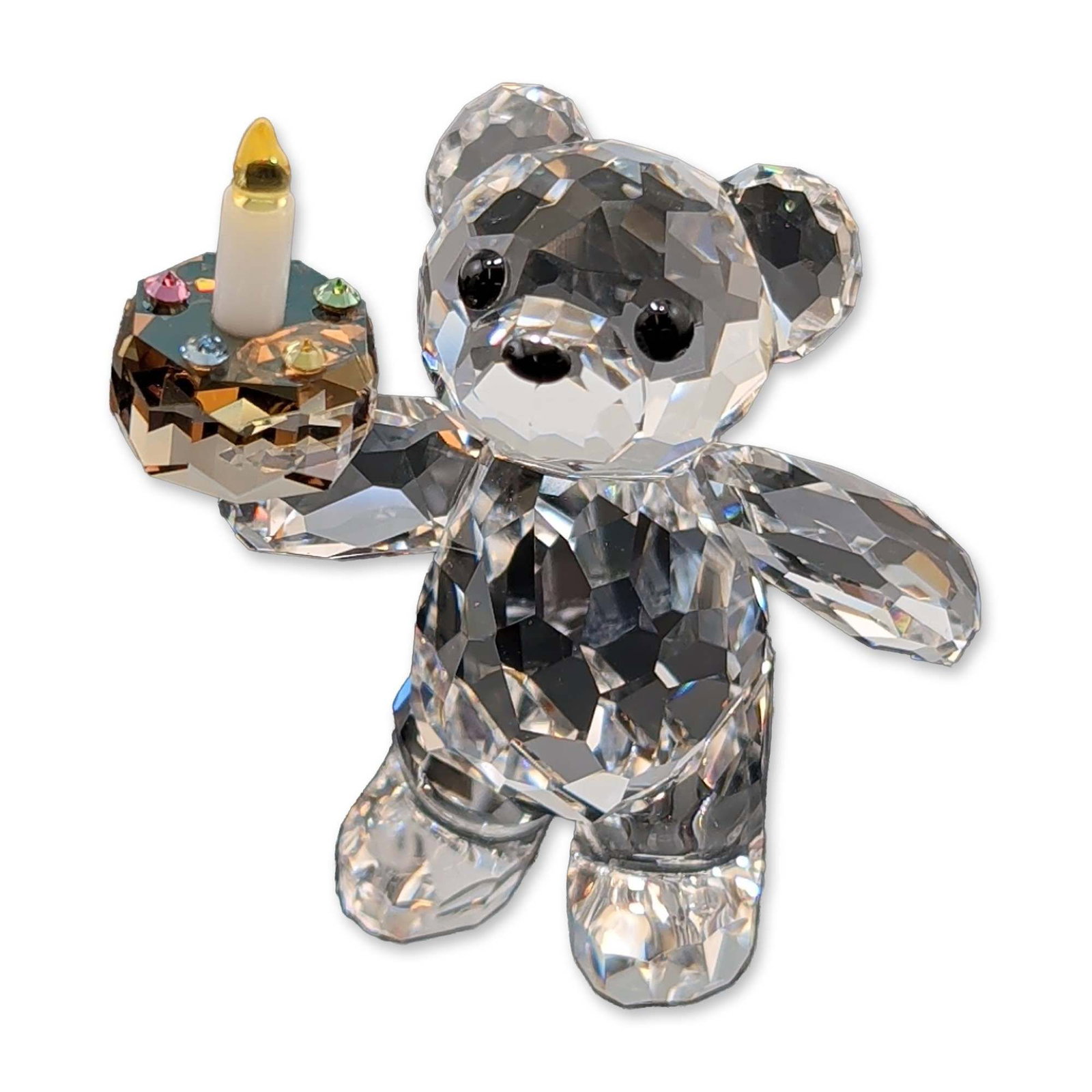 Swarovski Crystal Kris Bear Figurine, Your Big Day: Swarovski Kris Bear figurine in faceted clear crystal titled Your Big Day. Kris bear is depicted holding a celebratory cake embellished with multi-colored chaton crystals and a single candle with a ye