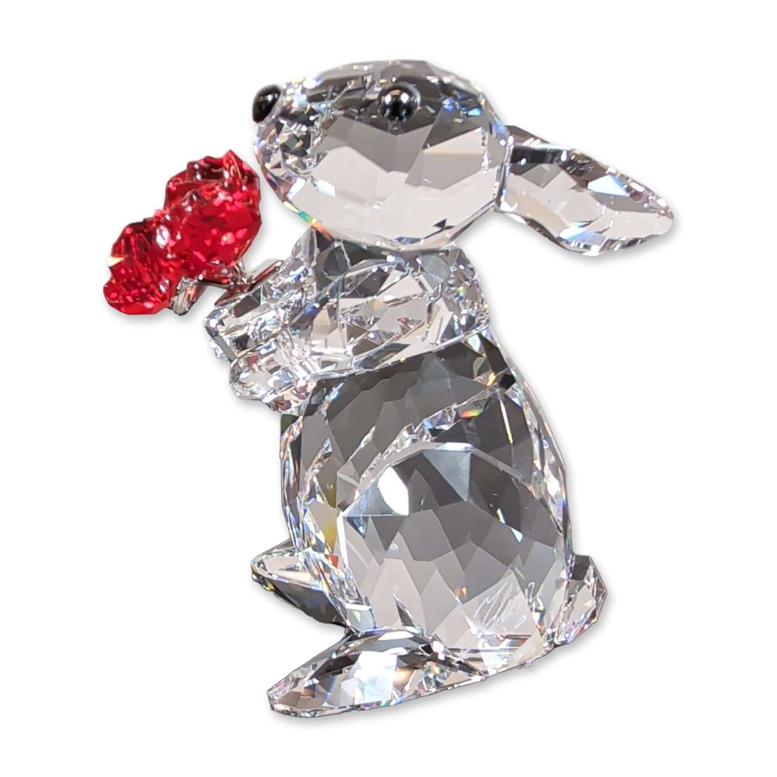 Swarovski Crystal Rabbit with Roses Figurine: Swarovski crystal figurine titled Rabbit with Roses. The piece is crafted from faceted clear crystal and depicts a rabbit in a seated pose holding a cluster of three red crystal roses. The rabbit is d