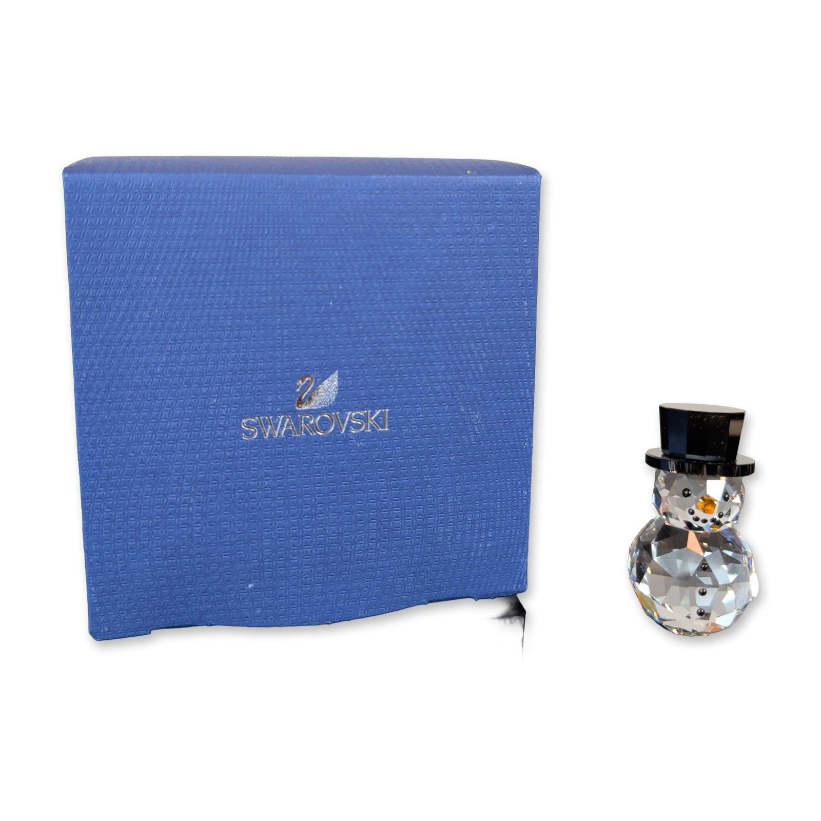 Swarovski Crystal Snowman Figurine: Swarovski Snowman figurine in faceted lead crystal, featuring a clear multi-faceted body with a black crystal top hat and amber-colored carrot nose. Adorned with black dot accents for the eyes, mouth,