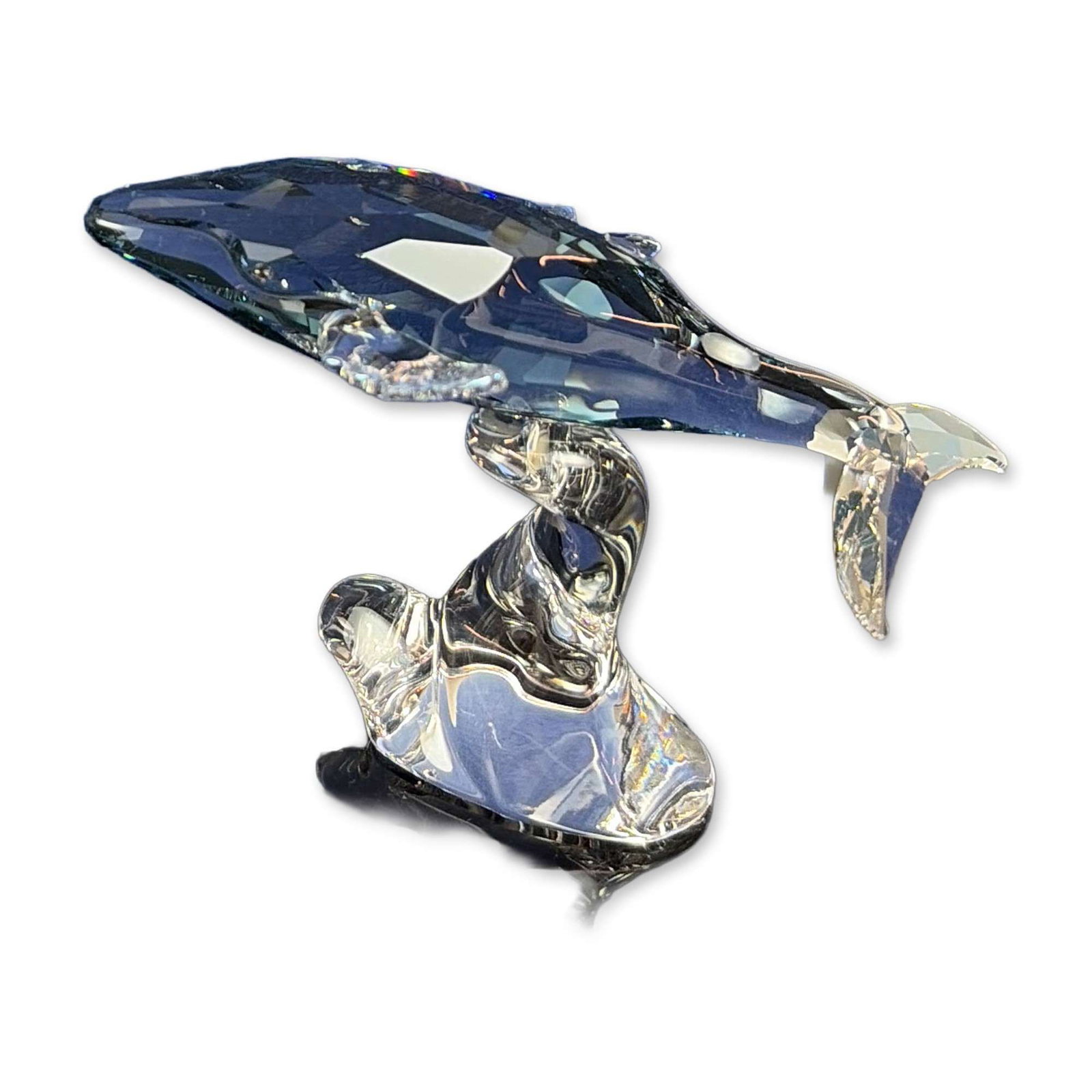 Swarovski Crystal Young Whale Figurine: This charming young whale sparkles in Shadow crystal with shimmering Crystal Moonlight fins. Its underside features an etched Swarovski swan logo and copyright symbol. Includes original blue Swarovski