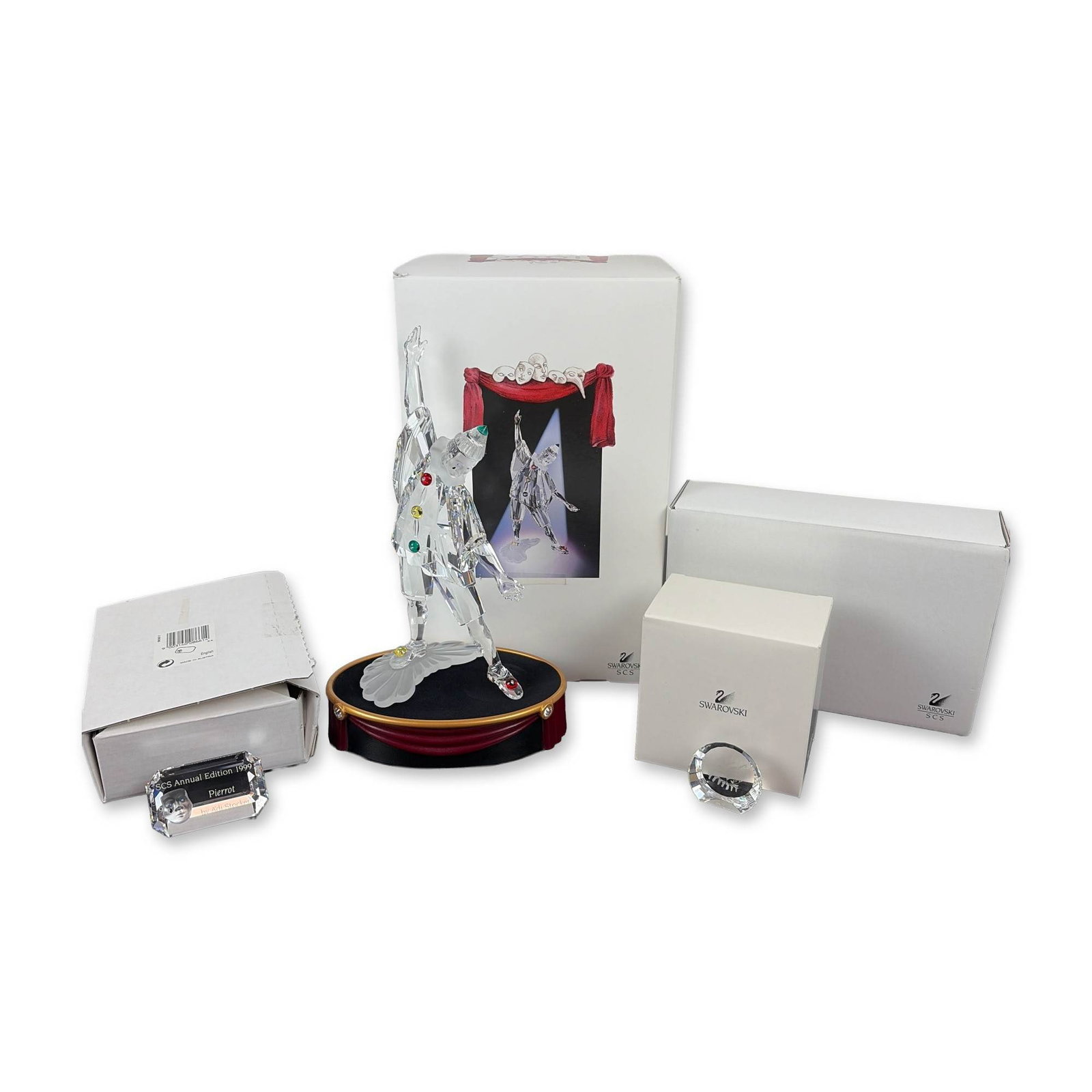 4pc Swarovski 1999 SCS Pierrot Figurine Collection: This 4-piece set from the Masquerade series includes a figurine, display base, and two name plaques. Crafted from faceted clear lead crystal with frosted accents and vibrant crystal buttons in red, ye
