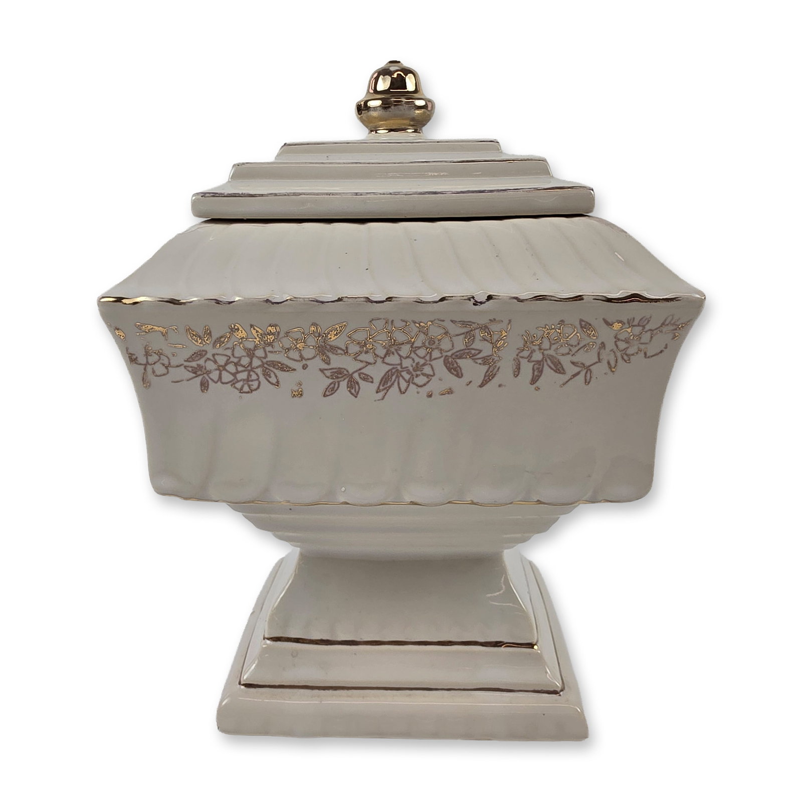 McCoy USA Wedding Cake Covered Jar: McCoy Pottery, USA. Mid-20th century footed square covered jar in the Wedding Cake pattern, produced in glazed earthenware with a cream finish. The form features a vertical fluted and scalloped body o