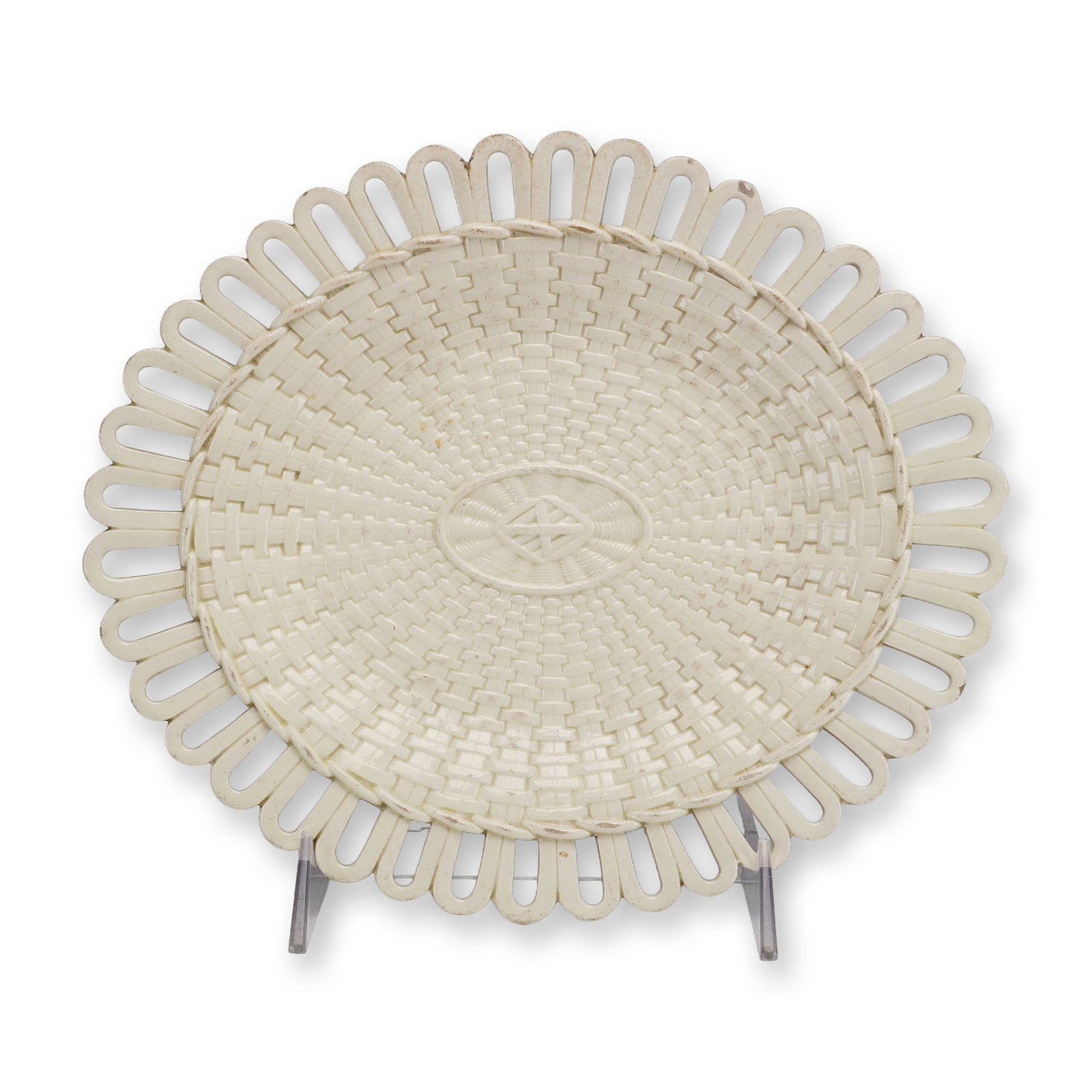 Wedgwood 18th Century Reticulated Creamware Oval Plate: The center of the dish features a molded basketweave, or osier, pattern radiating from a central oval medallion that contains an impressed geometric motif. The flared rim consists of a series of retic