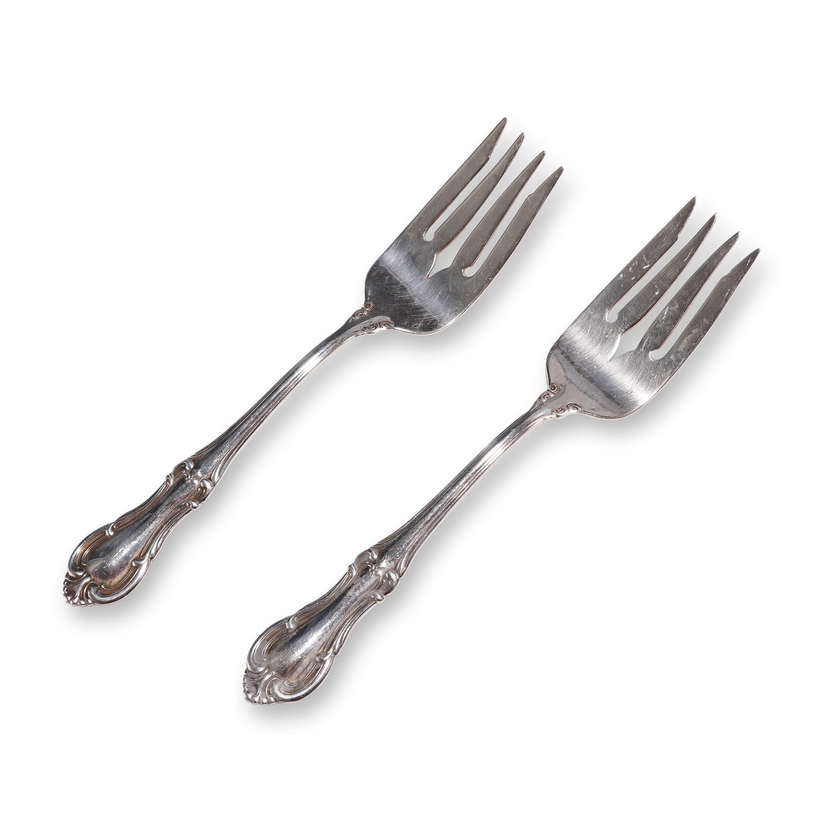Pair of International Sterling Salad Forks, Joan of Arc: International Silver Company sterling silver pair of individual salad forks in the Joan of Arc pattern, introduced in 1940. Each fork features a Rococo Revival style design with scrolled borders, leaf