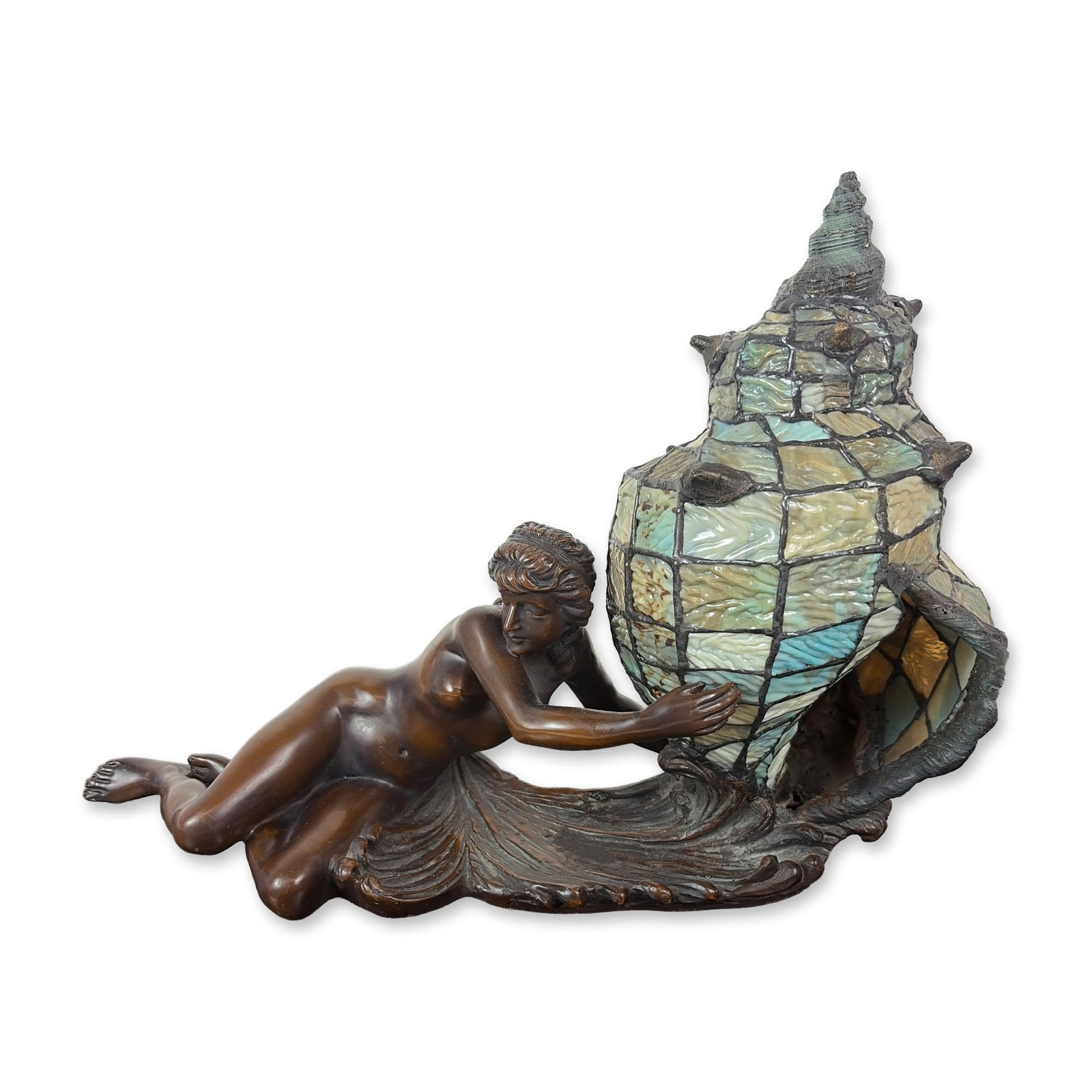 Bronze Nymph and Stained Glass Shell Lamp: Art Nouveau style table lamp featuring a cast bronze sculpture of a reclining nymph. The figure is realistically modeled alongside stylized wave forms that support a large leaded opalescent slag glass