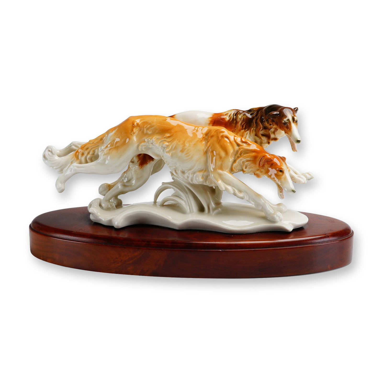 Karl Ens Attributed Porcelain Running Borzoi Sculpture: Art Deco style porcelain figural group attributed to Karl Ens, Germany. The polychrome sculpture depicts two Borzois, also known as Russian Wolfhounds, captured in a dynamic, mid-leap running stride. 