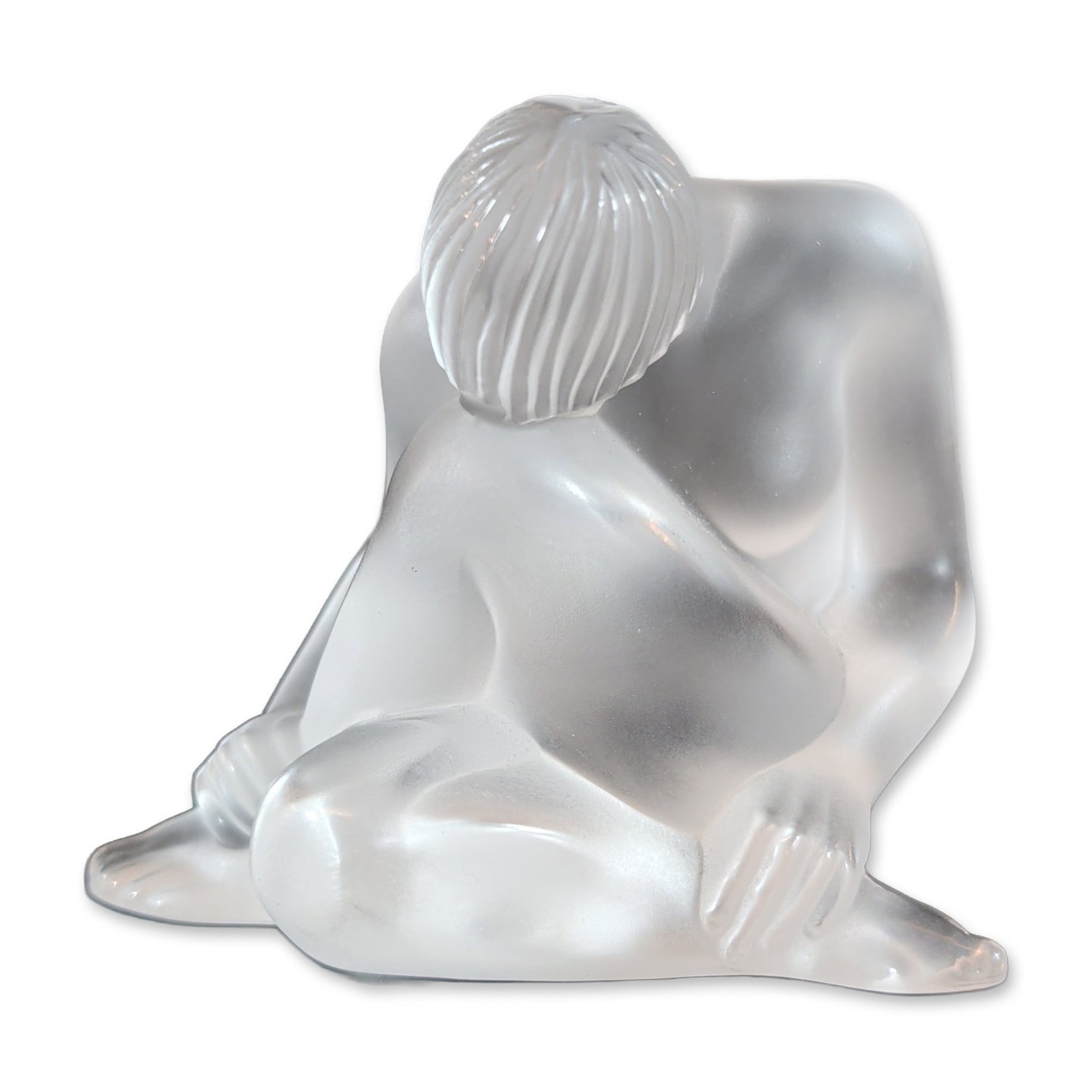 Lalique France Frosted Crystal Nu Assis Figurine: Lalique, France Nu Assis (Seated Nude) figurine in frosted lead crystal, depicting a stylized female nude in a crouching position with linear textured hair and smooth anatomical forms. The underside o