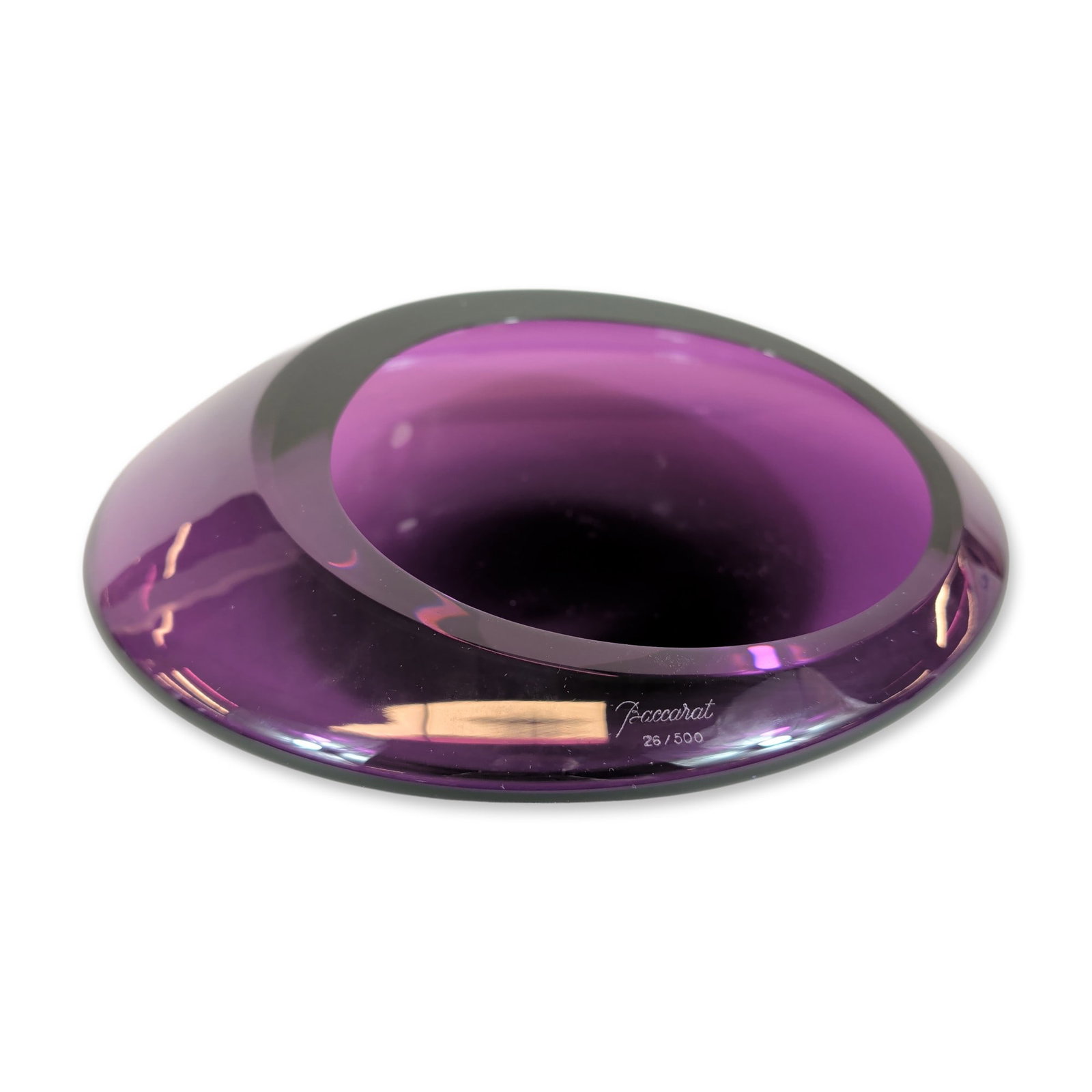 Baccarat Contemporary Amethyst Crystal Oval Dish: Thick-walled amethyst lead crystal dish of contemporary design, featuring a slanted, asymmetrical oval rim and highly polished surfaces. The side of the rim bears an engraved signature reading