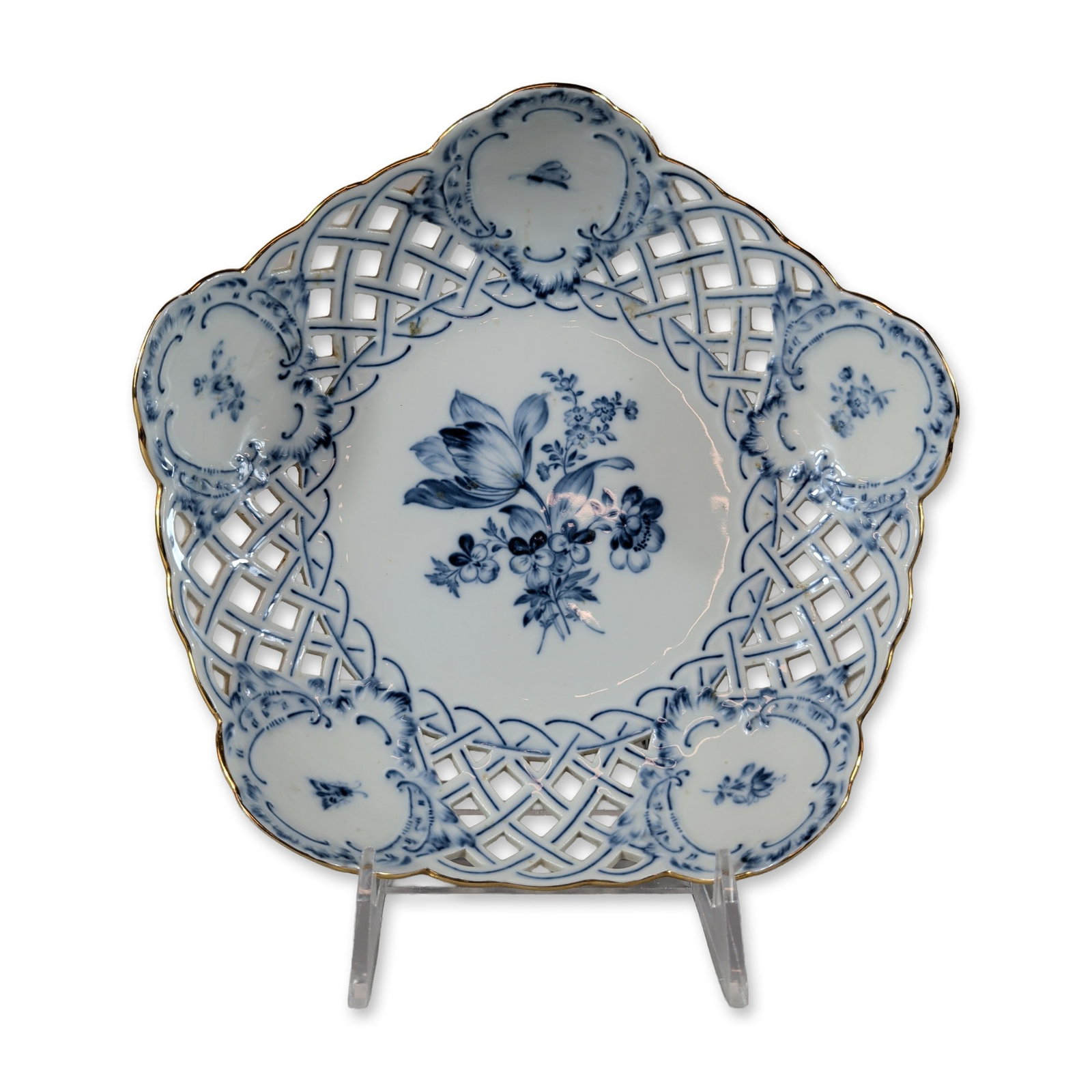Meissen Reticulated Blue Flower Porcelain Dish: Meissen (Germany). Trilobed reticulated dish in white porcelain. The vessel features a scalloped edge with a gilded rim and an openwork basketweave pattern border. The central interior is hand-painted