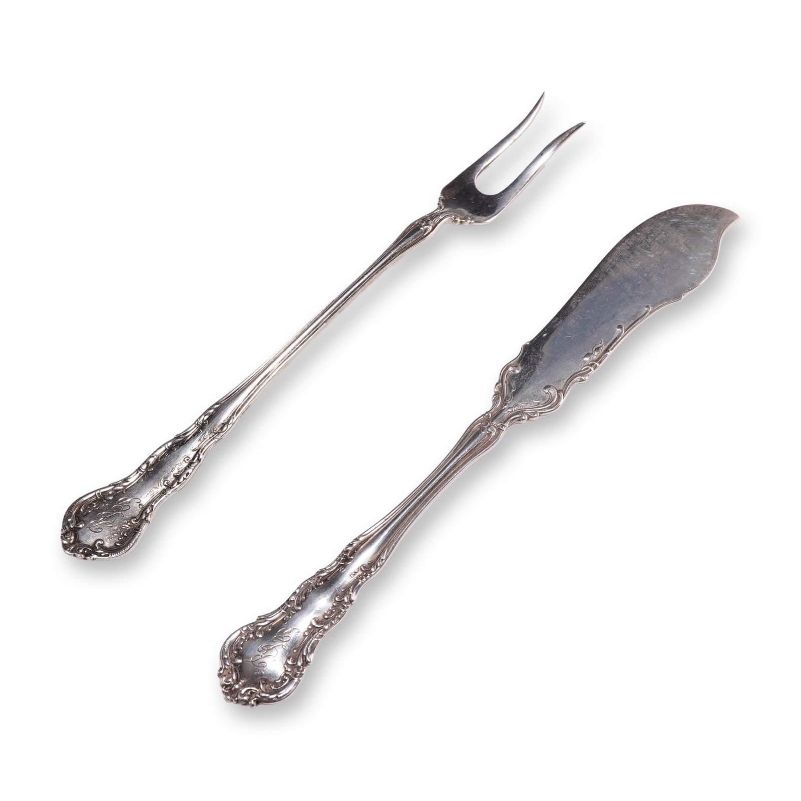 Wallace Sterling Silver Butter Knife and Olive Fork: R. Wallace & Sons sterling silver two-piece flatware serving set, patented in 1899. The set includes a flat-handle master butter knife and a two-tine olive fork. Each piece features ornate Rococo Revi