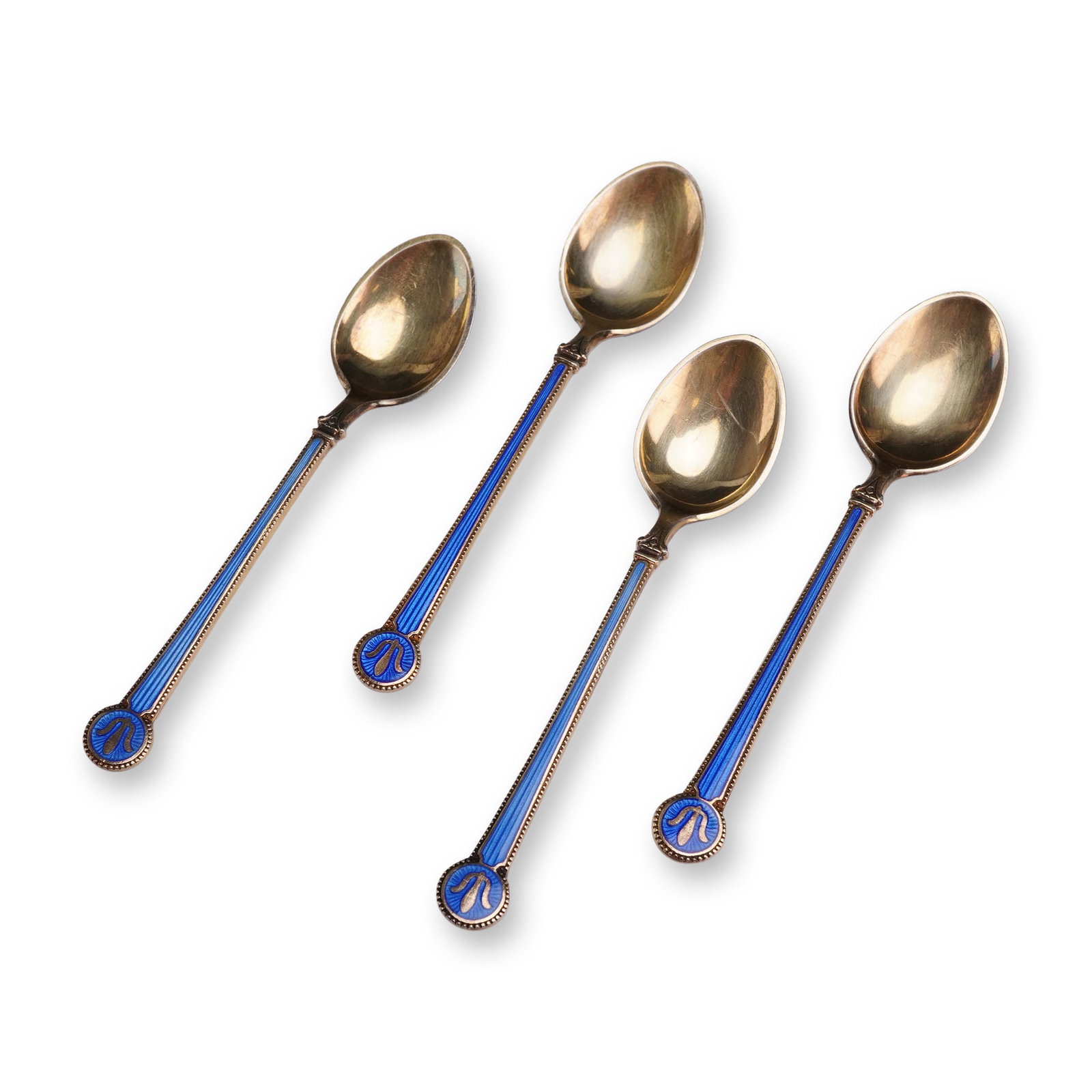 Set of Four David Andersen Norwegian Gilt Sterling and Enamel Spoons: David-Andersen (Norway, mid-20th century). Set of four demitasse spoons in gold-gilded sterling silver (vermeil) and guilloche enamel. Each spoon features vibrant royal blue transparent enamel over an