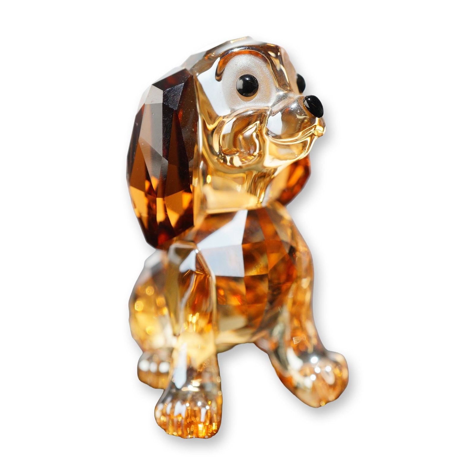 Swarovski Crystal Disney Danielle Figurine: Swarovski crystal figurine depicting the Disney character Danielle from Lady and the Tramp, model number 1089222. The figure is modeled in a seated pose of faceted amber and golden-brown crystal, with
