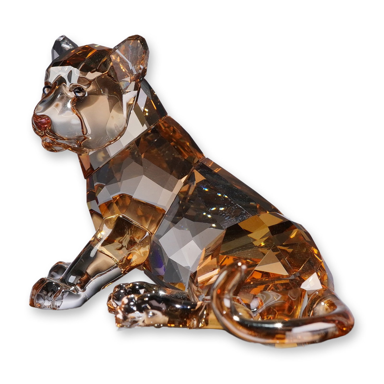 Swarovski SCS 2010 Annual Edition Figurine, Tiger Cub Sitting: Swarovski Crystal Society (SCS) 2010 annual edition crystal figurine of a sitting tiger cub. The figure is rendered in faceted golden-amber shadow crystal with clear crystal paws. Features an etched S